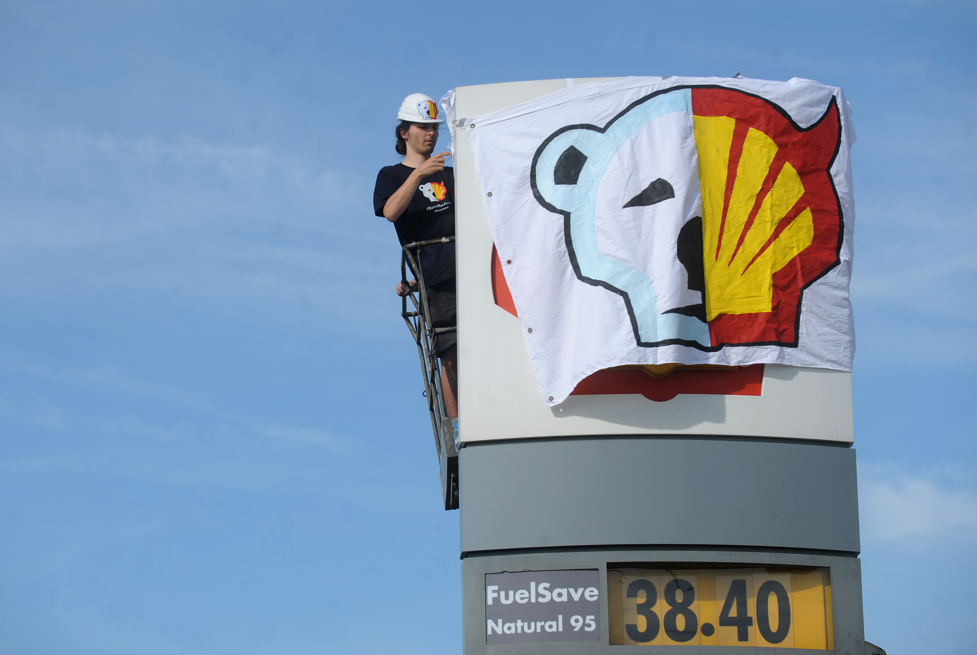A Greenpeace activist covers the logo of