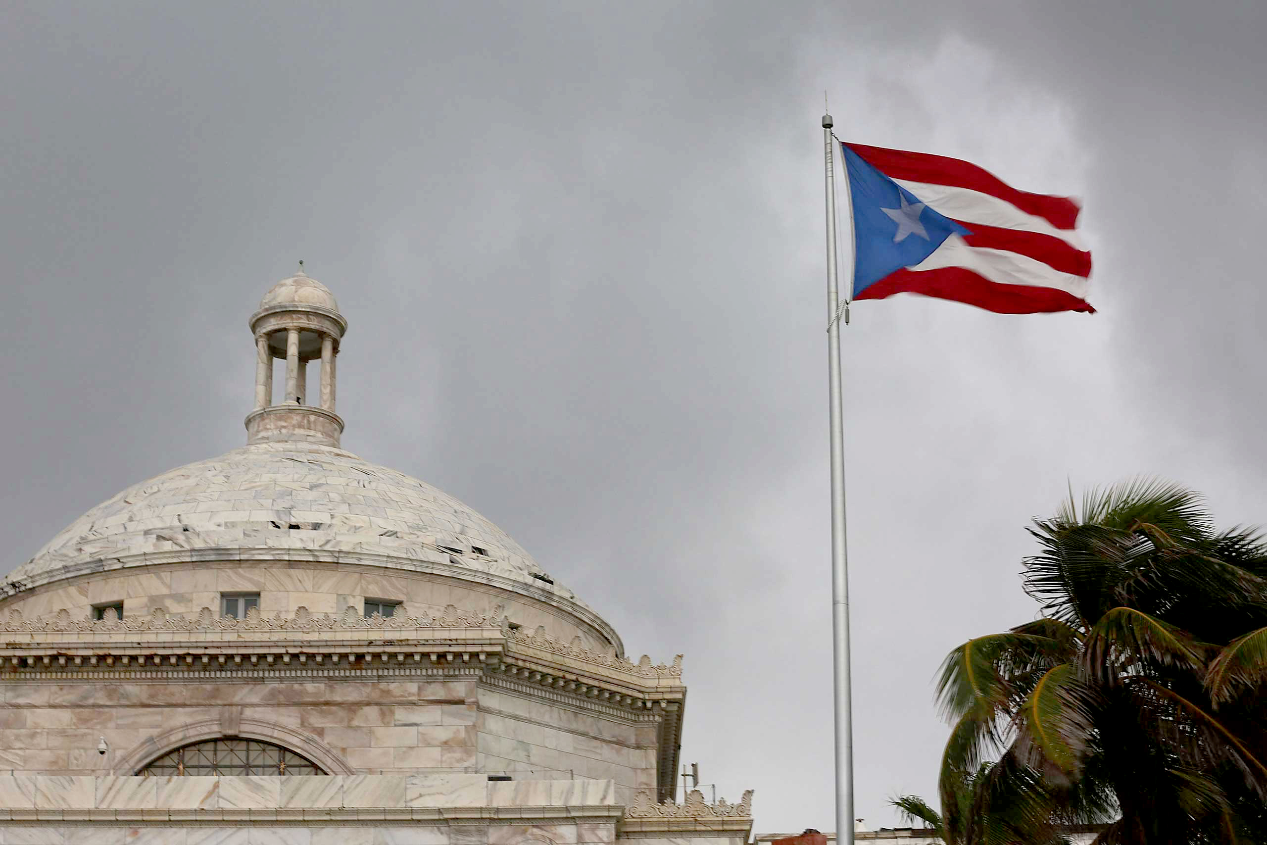 The Puerto Rican flag flies near the Capitol building as the island's residents deal with the government's $72 billion debt on July 1, 2015 in San Juan. (Joe Raedle—Getty Images)