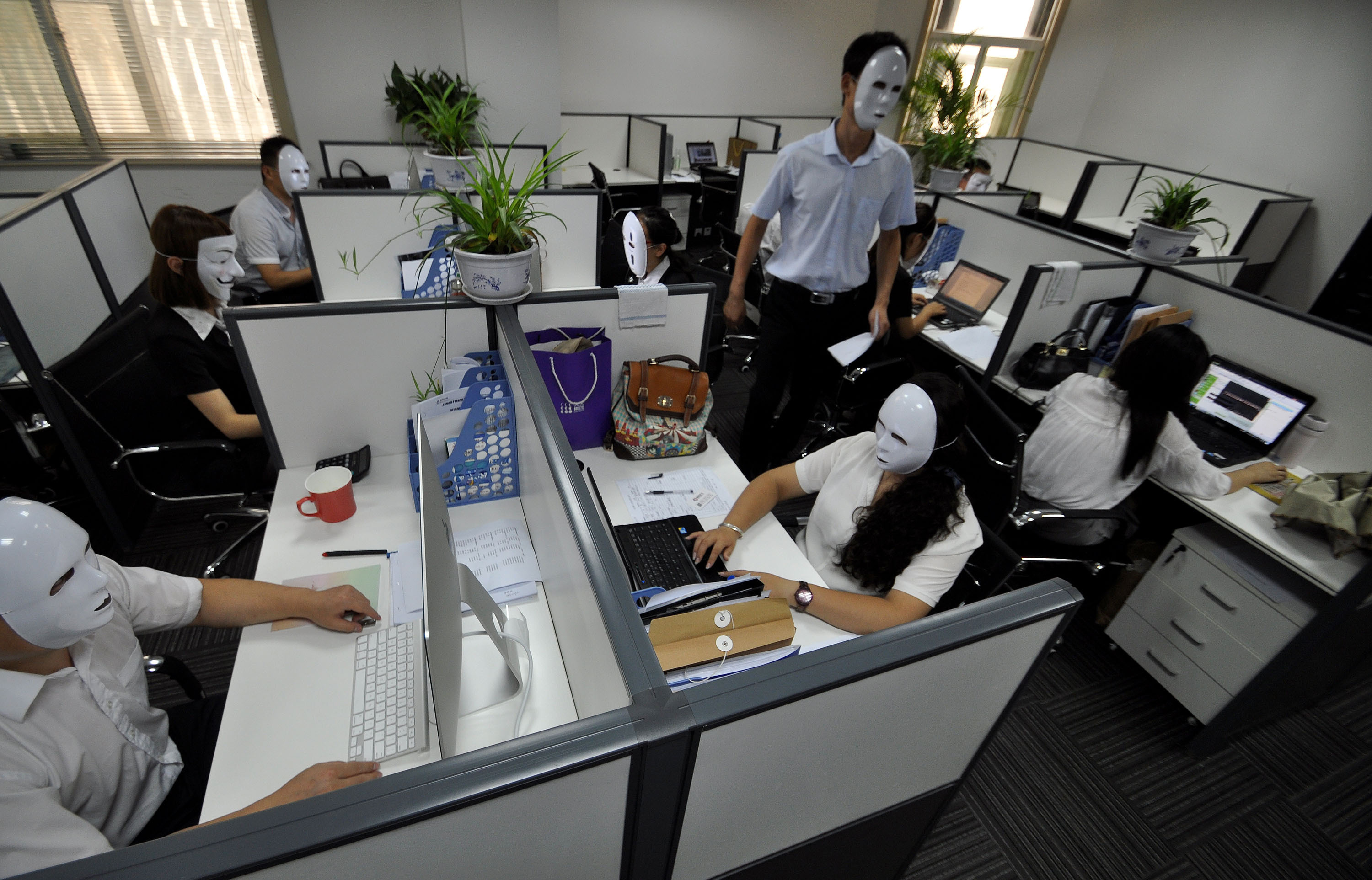 Chinese workers wearing no-face masks. (ChinaFotoPress&mdash;ChinaFotoPress via Getty Images)