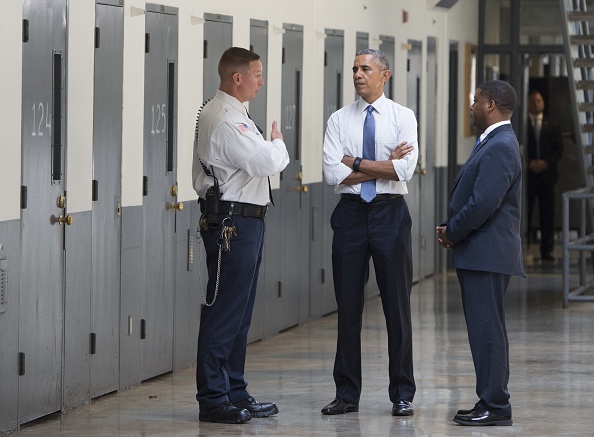President Barack Obama, alongside Charles Samuels (R), Bureau of Prisons Director, and Ronald Warlick (L), a correctional officer, tours a cell block at the El Reno Federal Correctional Institution in El Reno, Oklahoma, on July 16, 2015.