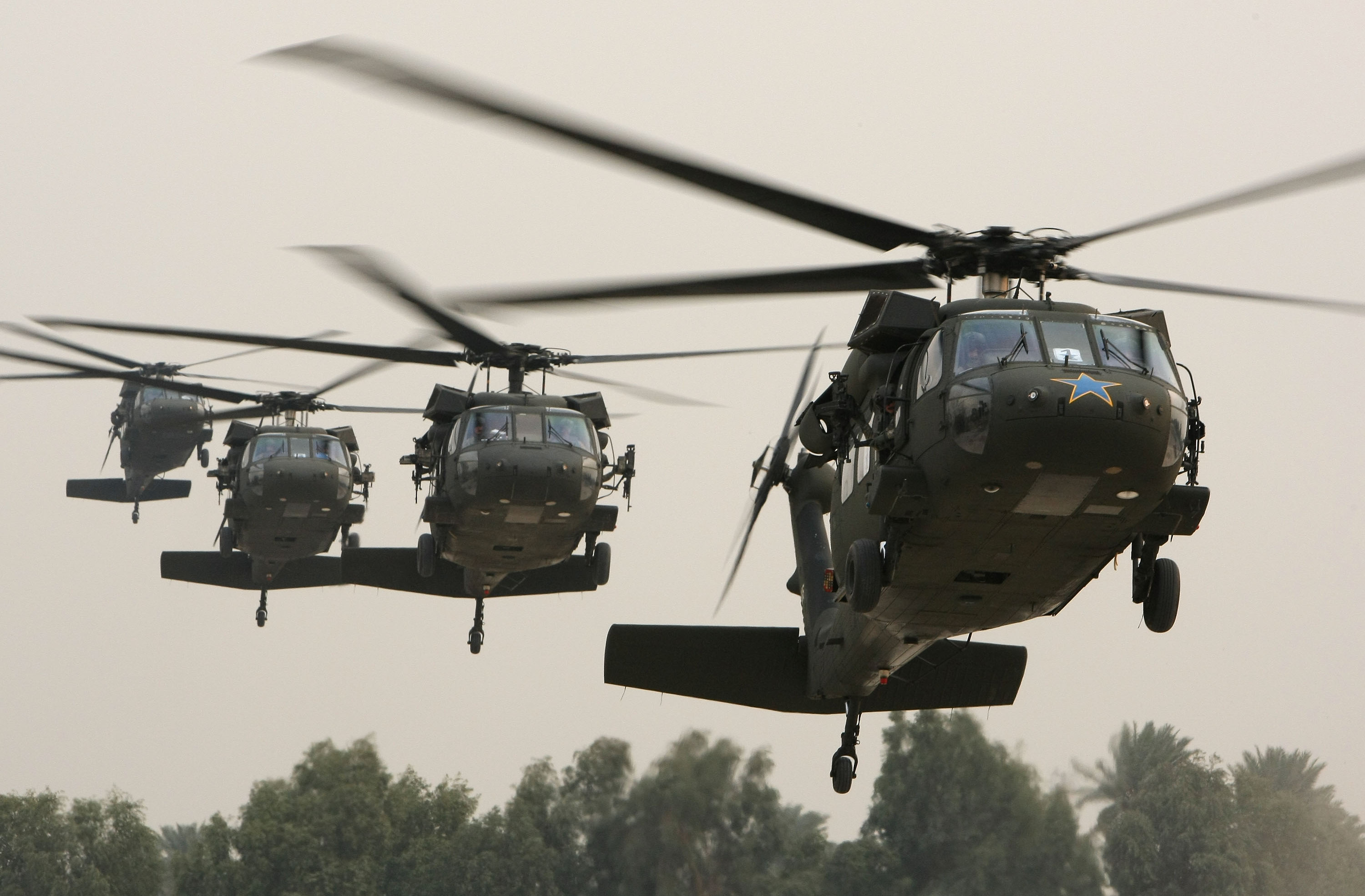 A Blackhawk helicopter (R) carrying U.S. Secretary of Defense Robert Gates arrives in the Green Zone December 10, 2009 in Baghdad, Iraq. (Justin Sullivan—Getty Images)