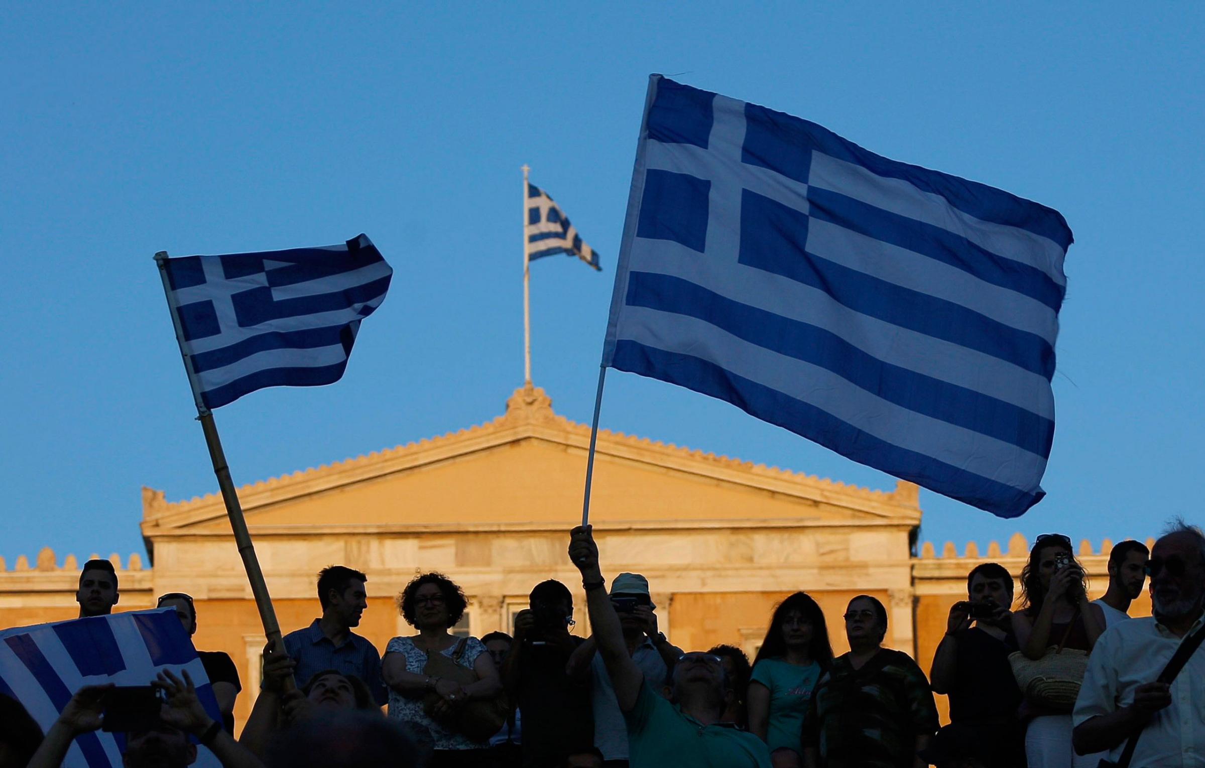 Supporters of the "No" vote wave Greek flags after the referendum's exit polls at Syntagma square in Athens, Sunday, July 5, 2015.