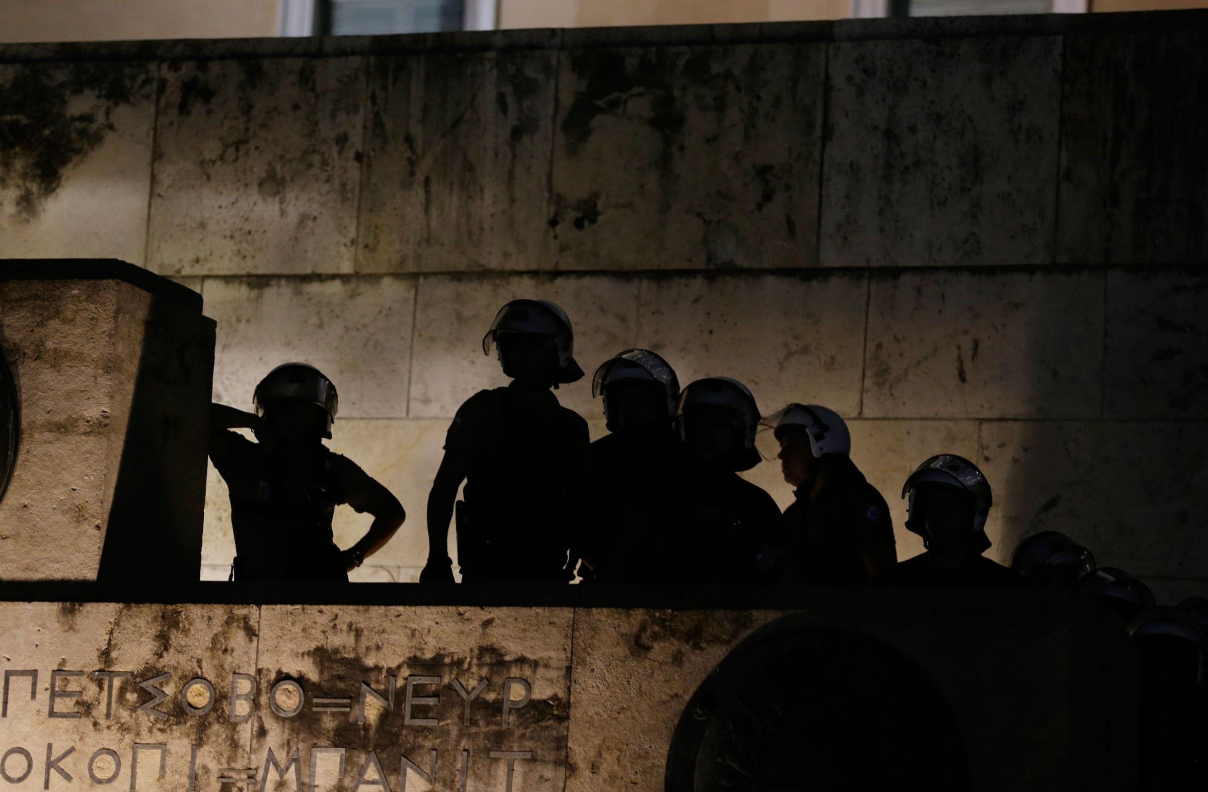 Riot policemen guard an entrance of the parliament as supporters of the No vote celebrate after the results of the referendum at Syntagma Square.