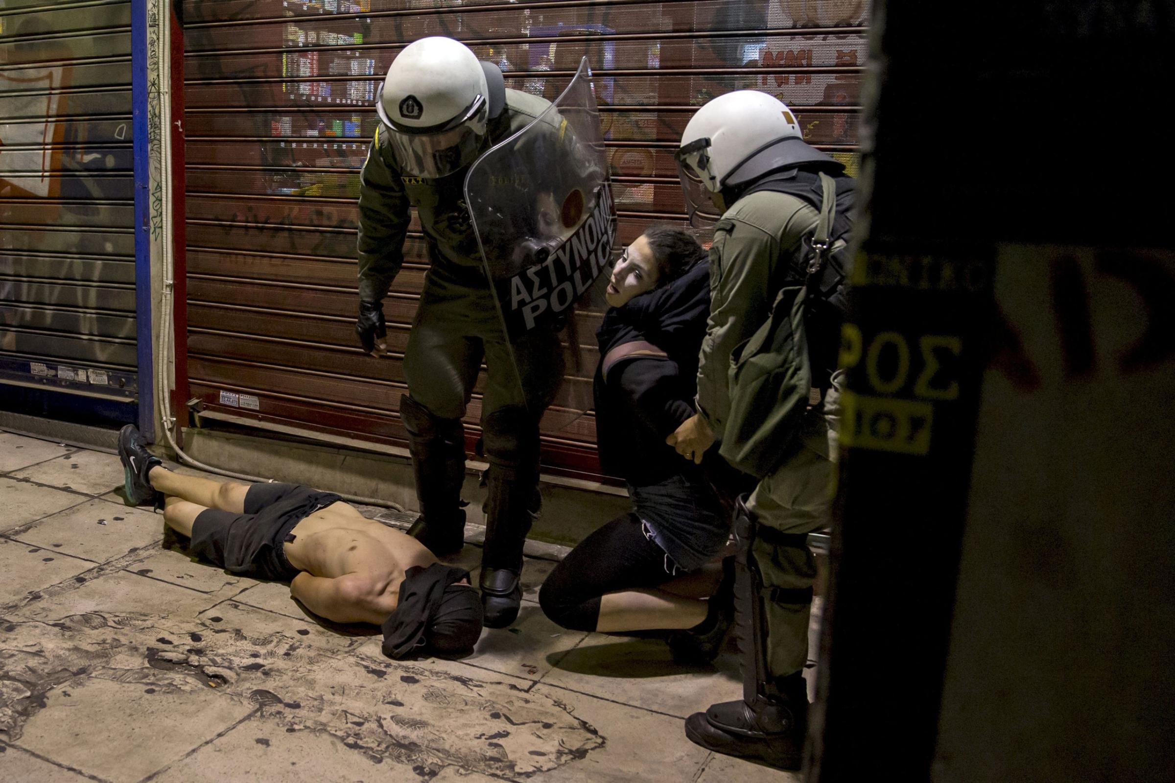 Riot police detain masked youth during minor clashes in central Athens, Greece early July 6, 2015.