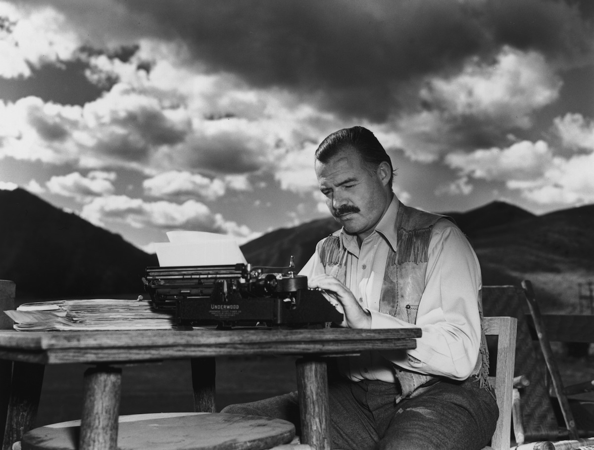 Ernest Hemingway works at his typewriter while sitting outdoors, in Idaho on Oct. 7, 1939 (Lloyd Arnold—Getty Images)