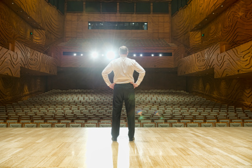 man-standing-empty-auditorium