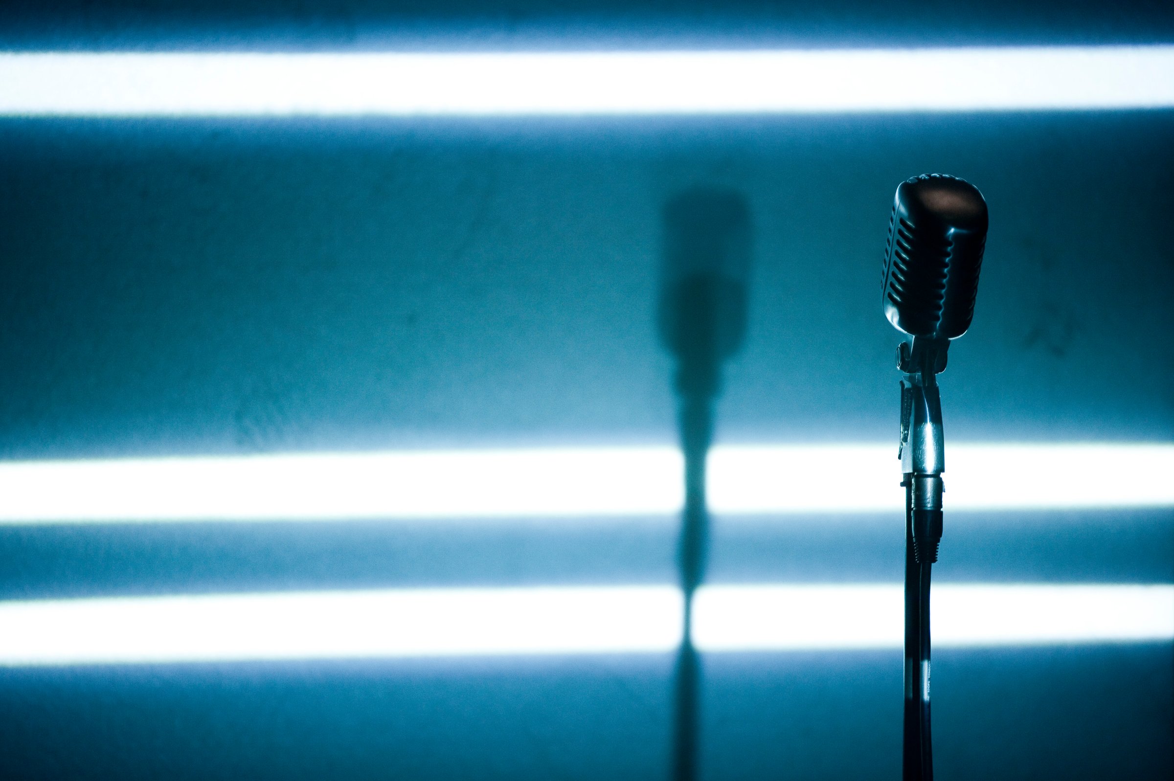 A microphone backlit on a stage