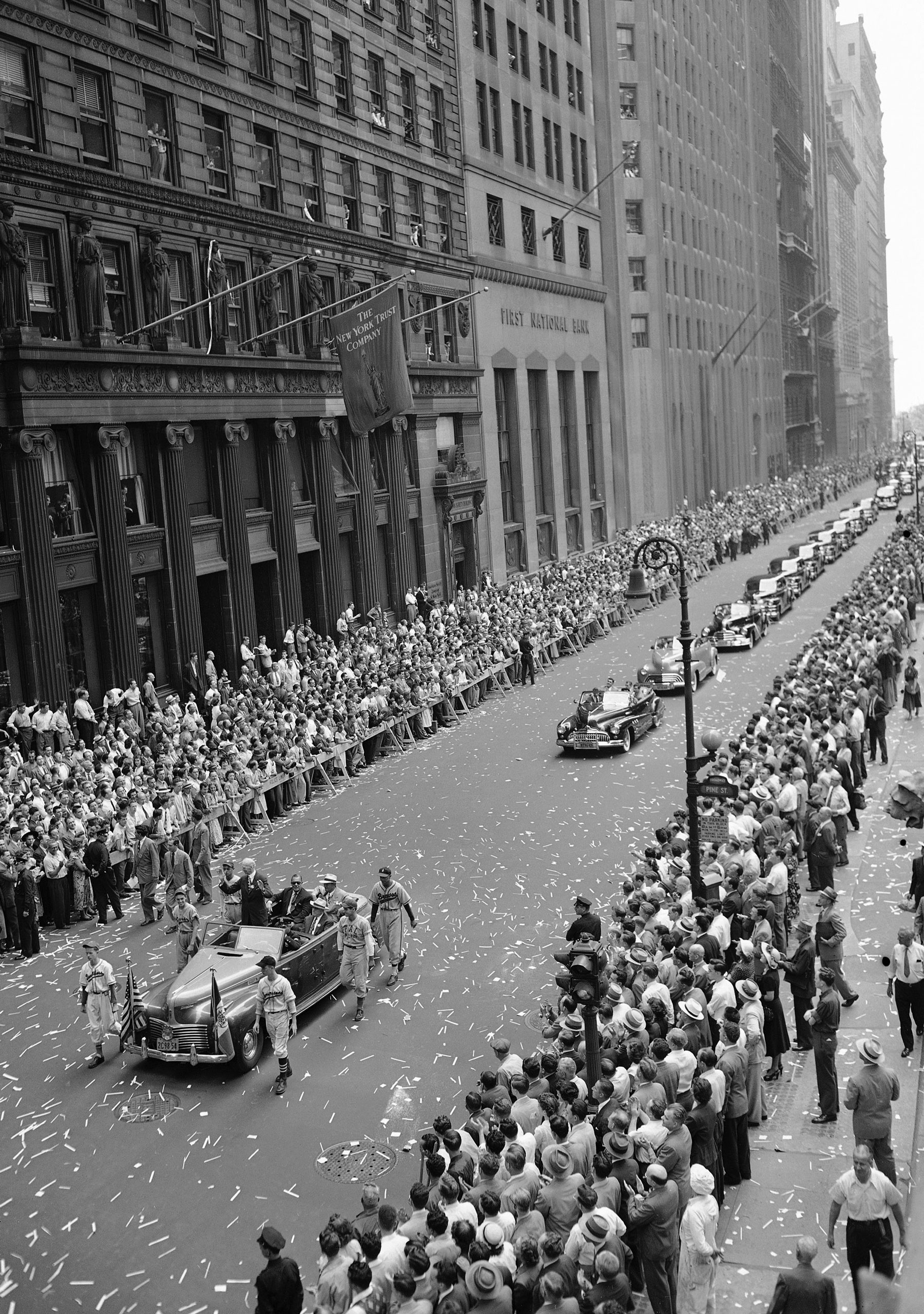 Baseball's grand old man, Connie Mack, stands up in a car, lower left, to acknowledge the cheers of New Yorkers lining lower Broadway, New York City, as a parade held in his honor moves past Pine Street towards City Hall and an official welcome, Aug. 19, 1949. Seated in the car with him are Grover Whalen, chairman of the mayor's reception committee; Del Webb, co-owner of the Yankees; and Edward G. Barrow, former Yankees executive. In following car are Yankee players Joe DiMaggio and his young son Joe Jr., Charlie Silvera, Joe Page and Johnny Lindell. (AP Photo)