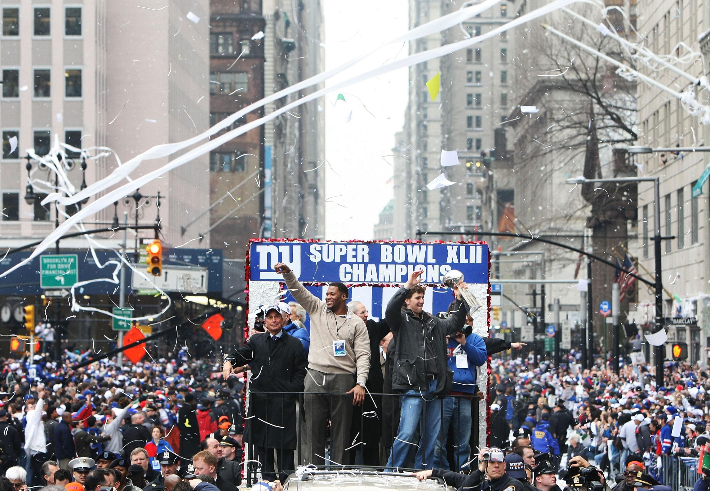 NEW YORK - FEBRUARY 05: (L-R) Mayor of New York Michael Bloomberg, Michael Strahan, and Eli Manning of the New York Giants ride in a float along Broadway, also known as "The Canyon of Heroes" during Super Bowl XLII victory parade in New York City.