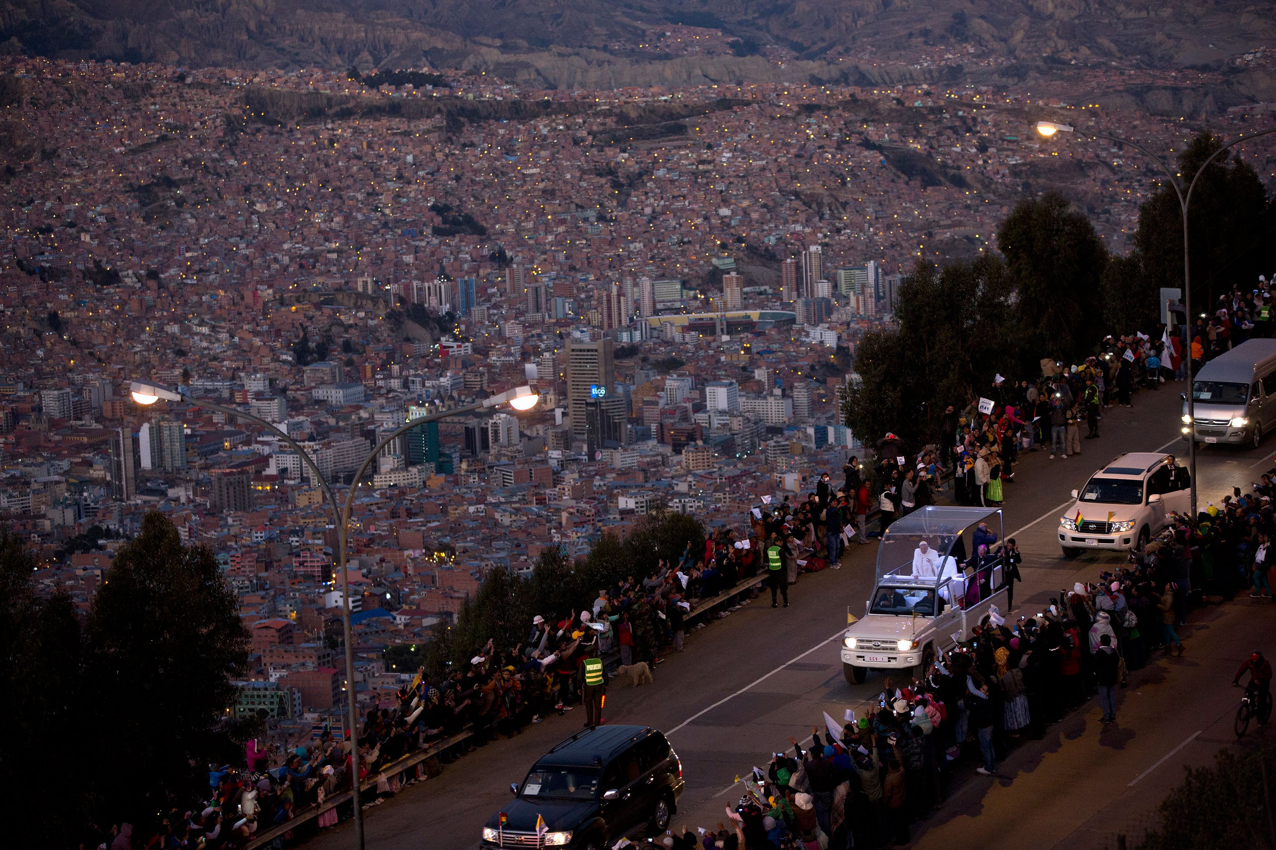 Pope Francis waves to the crowd lining the road to La Paz, as he rides aboard the popemobile from El Alto, Bolivia, on July 8, 2015.