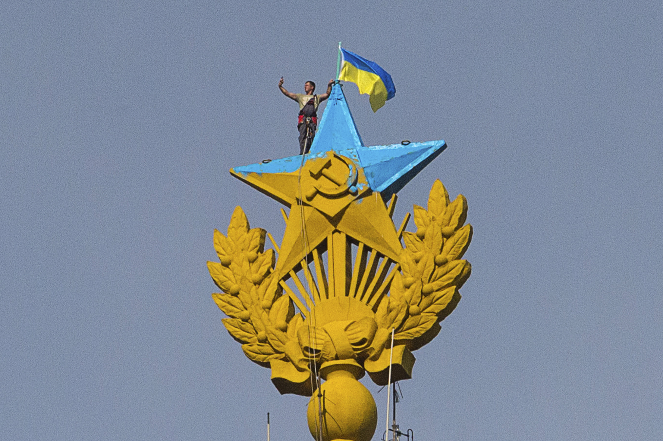 A man takes a 'selfie' as he stands with a Ukrainian flag on a Soviet-style star atop the spire of a building in Moscow. (© Stringer . / Reuters&mdash;REUTERS)