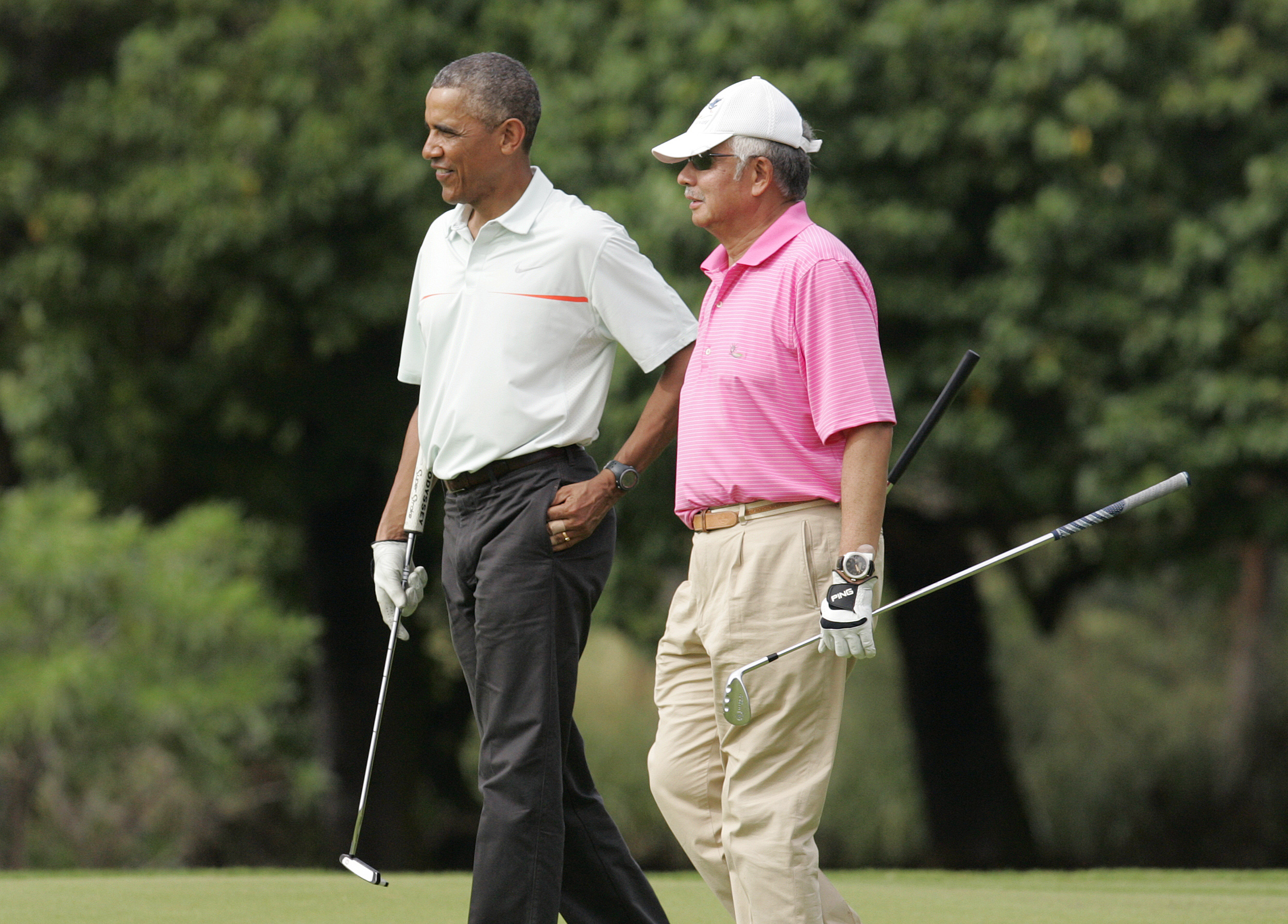 U.S. President Barack Obama and Malaysia's Prime Minister Najib Razak walk off 18th hole while playing a round of golf at the Clipper Golf course in Hawaii