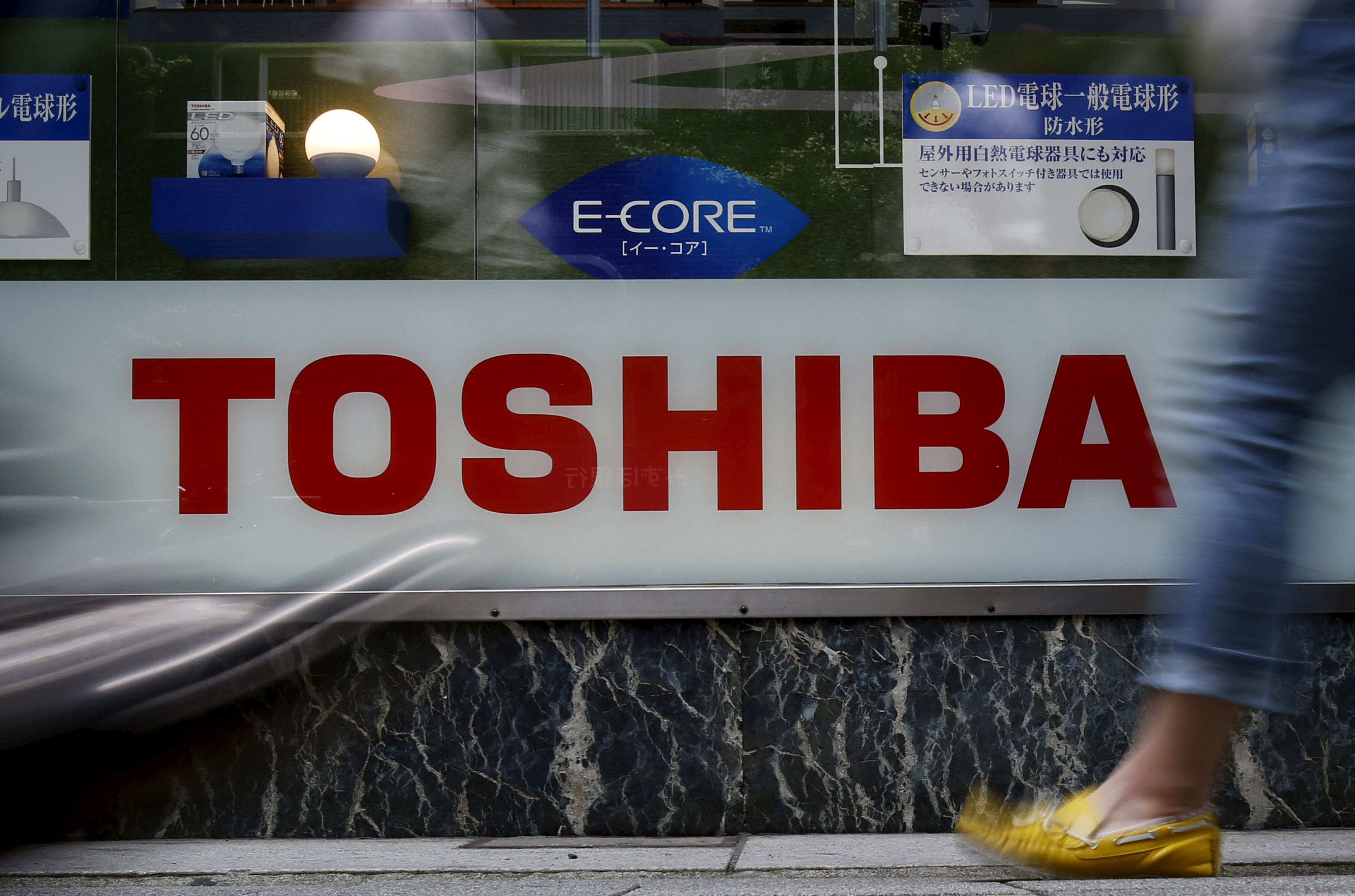 Pedestrians walk past a logo of Toshiba Corp outside an electronics retailer in Tokyo, Japan, June 25, 2015 (Yuya Shino—Reuters)