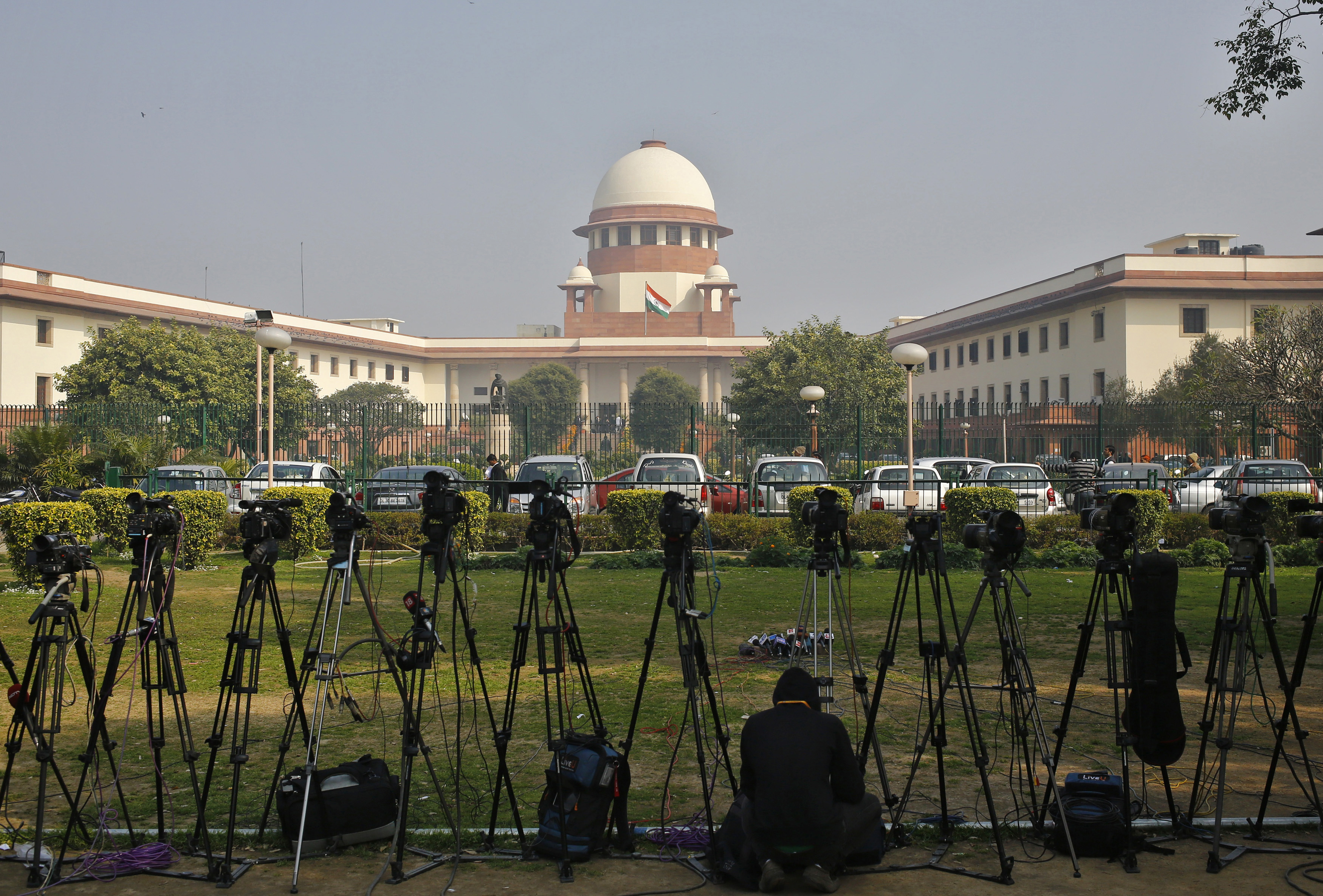 A television journalist sets his camera inside the premises of the Supreme Court in New Delhi