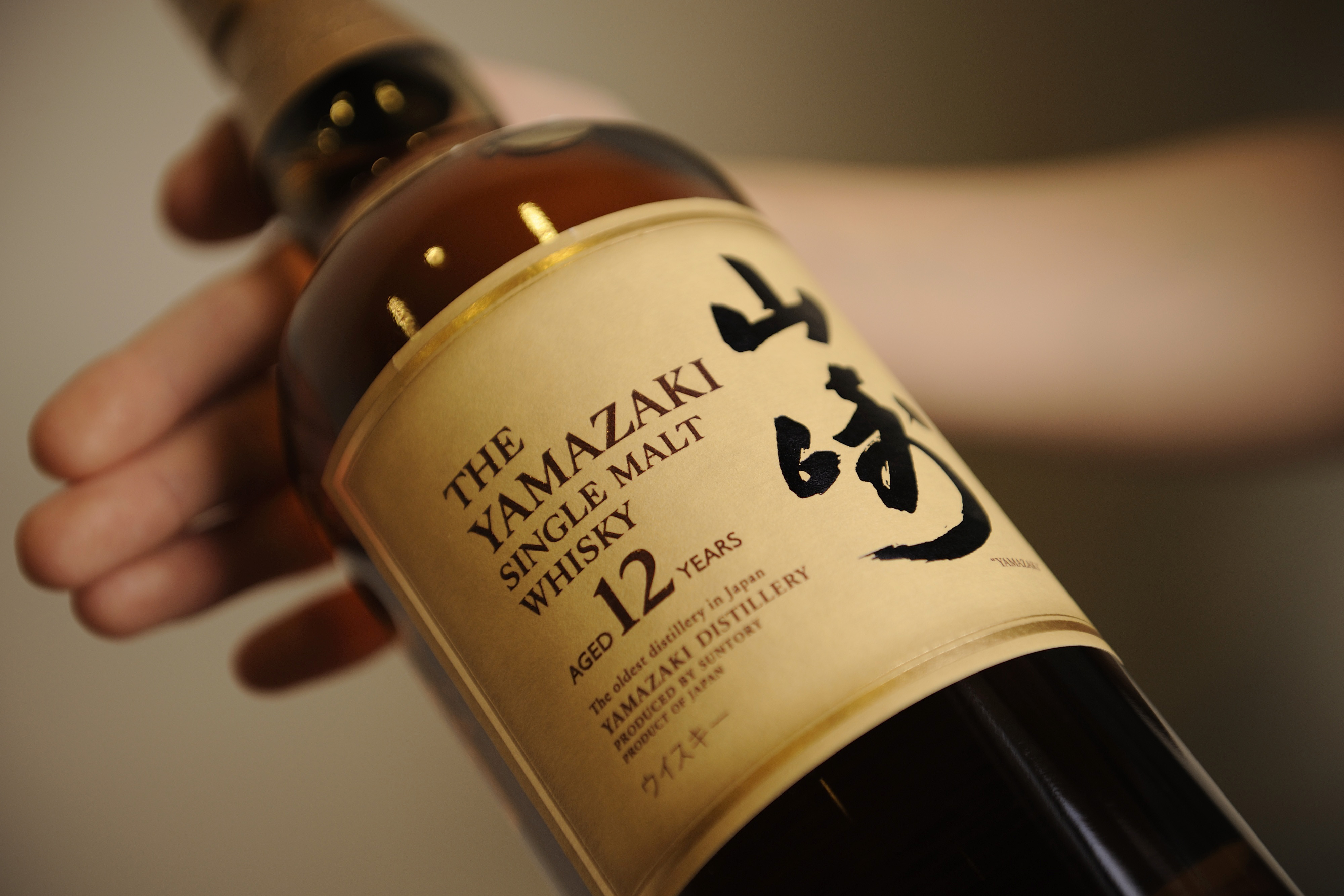 An employee holds a bottle of Suntory Holdings Ltd.'s Yamazaki whisky at the company's Yamazaki distillery in Shimamoto, Osaka, Japan, on Friday, Sept. 13, 2013. (Akio Kon—Bloomberg/Getty Images)