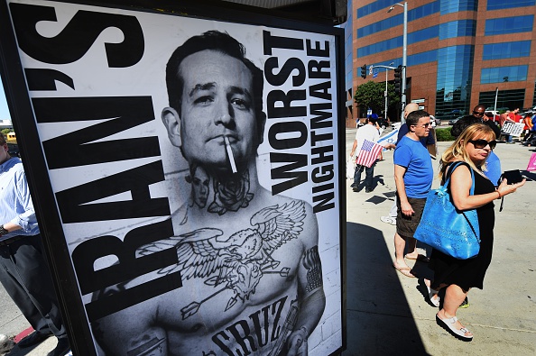 People walk past posters supporting politician Ted Cruz put up by the 'StandWithUs' group during a rally calling for the rejection of the proposed Iran nuclear deal outside the Federal Building in Los Angeles, California on July 26, 2015.