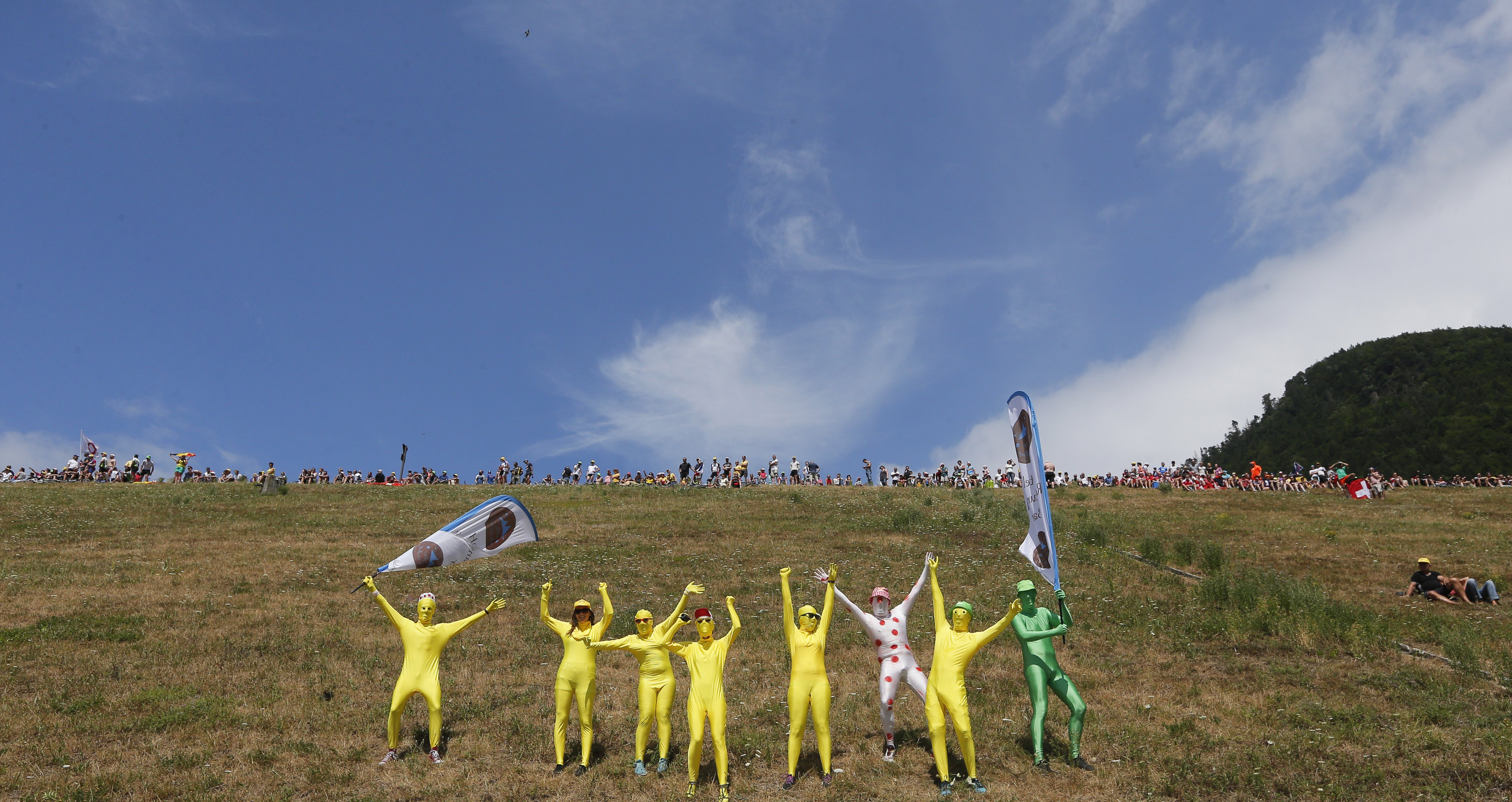 Disguised spectators cheer as riders pass during the 18th stage of the race ending in Saint-Jean-de-Maurienne, France on July 23, 2015.
