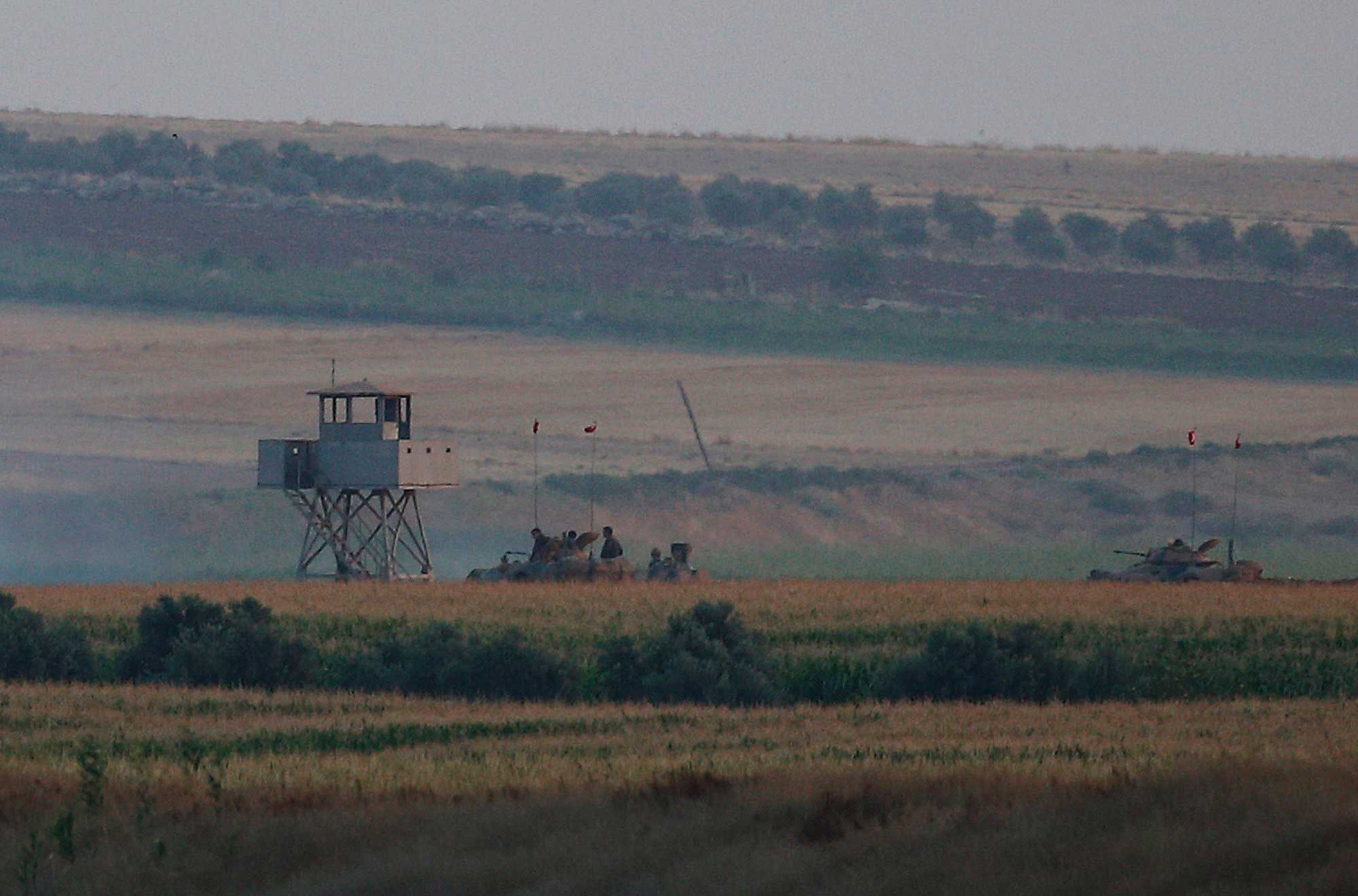 Turkish army tanks hold positions next to an outpost, near the border with Syria, on July 23, 2015. (Emrah Gurel—AP)
