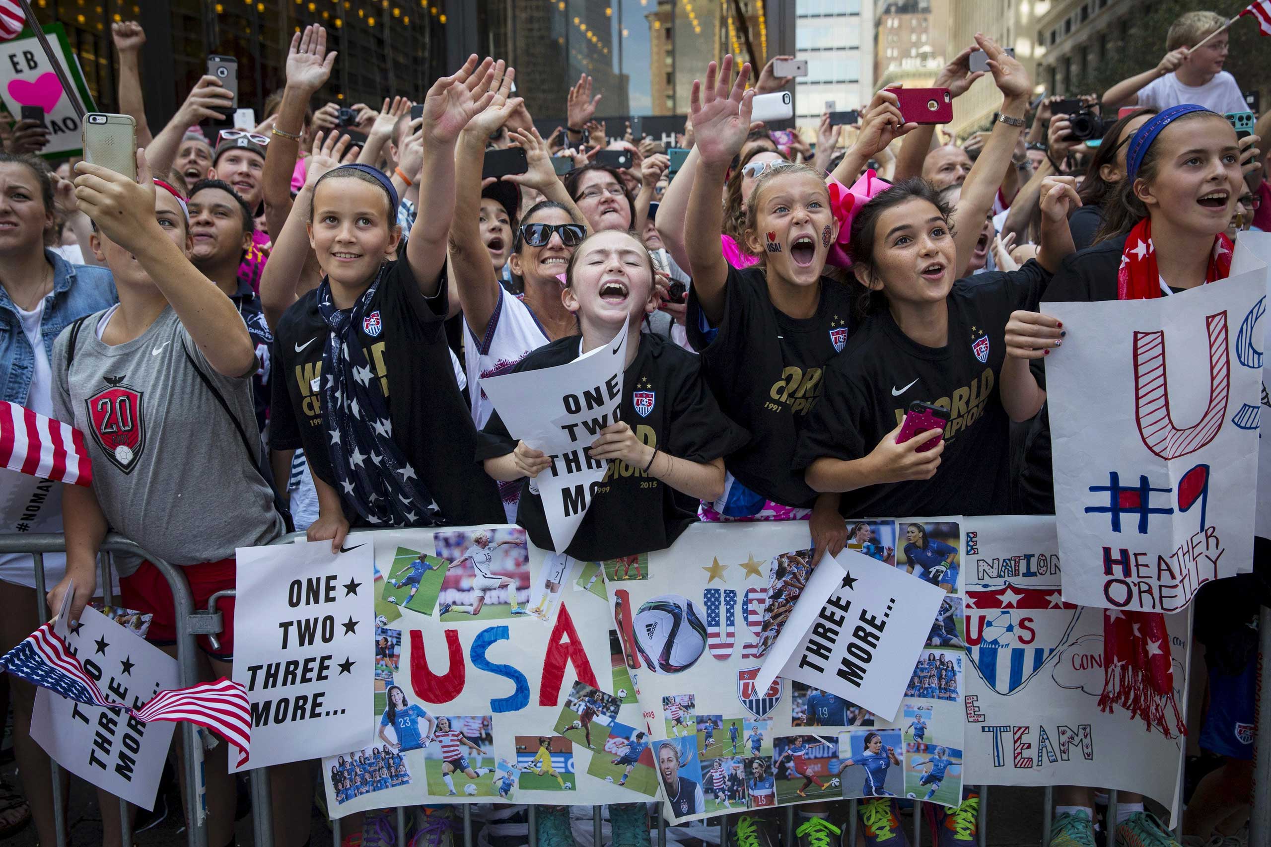 Fans of the U.S. women's soccer team cheer during the ticker tape parade to celebrate their World Cup victory, in New York City on July 10, 2015.