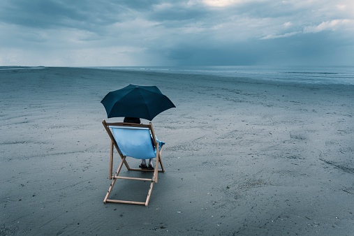 woman-sitting-beach-dark-sky