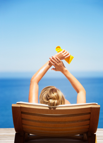 woman-sitting-sun-beach-cream