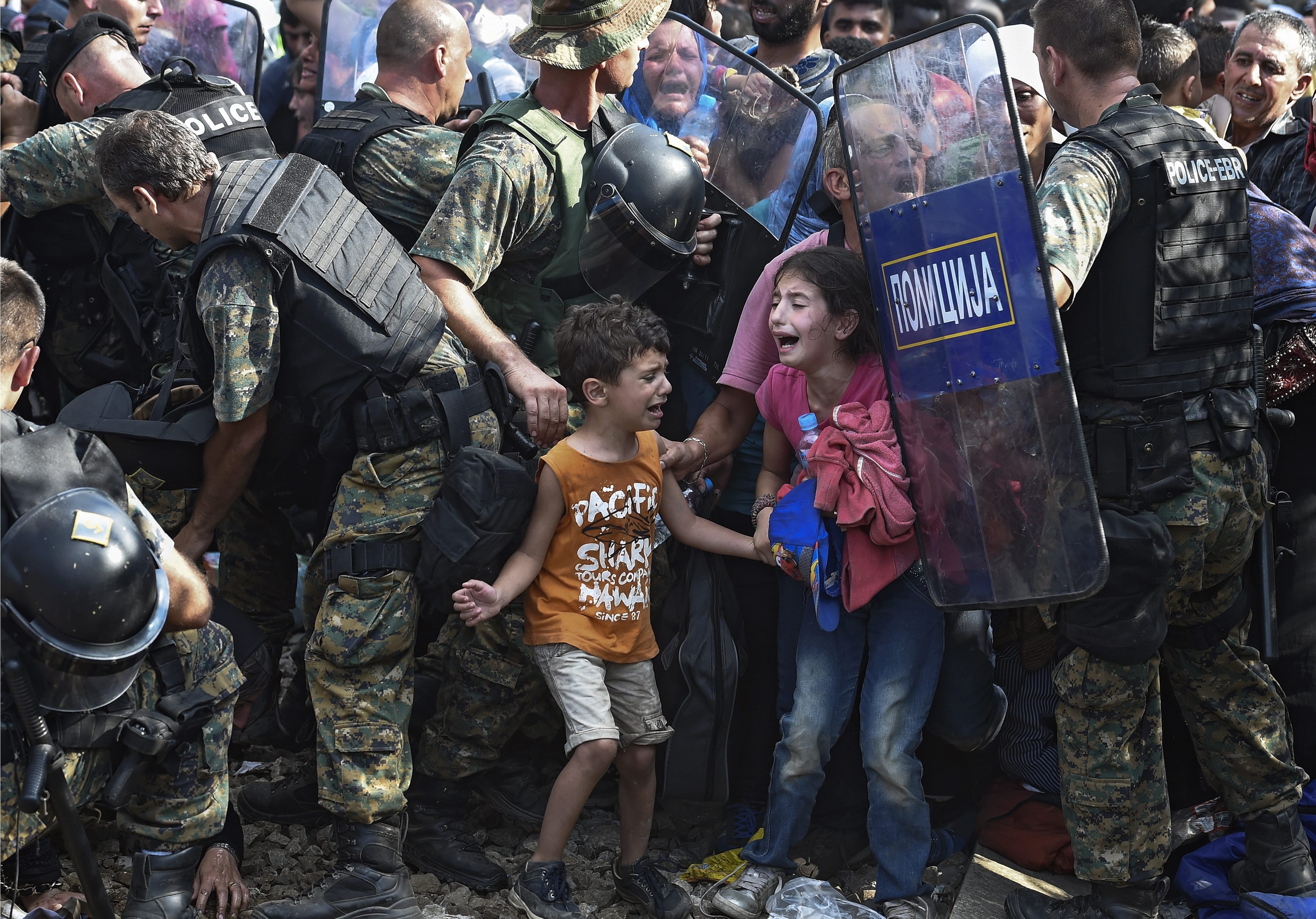 Children cry as migrants waiting on the Greek side of the border break through a cordon of Macedonian special police forces to cross into Macedonia, near the southern city of Gevgelija, The Former Yugoslav Republic of Macedonia on Aug. 21, 2015. Macedonian police clashed with thousands of migrants attempting to break into the country after being stranded in no-man's land overnight, marking an escalation of the European refugee crisis for the Balkan country. (Georgi Licovski—EPA)