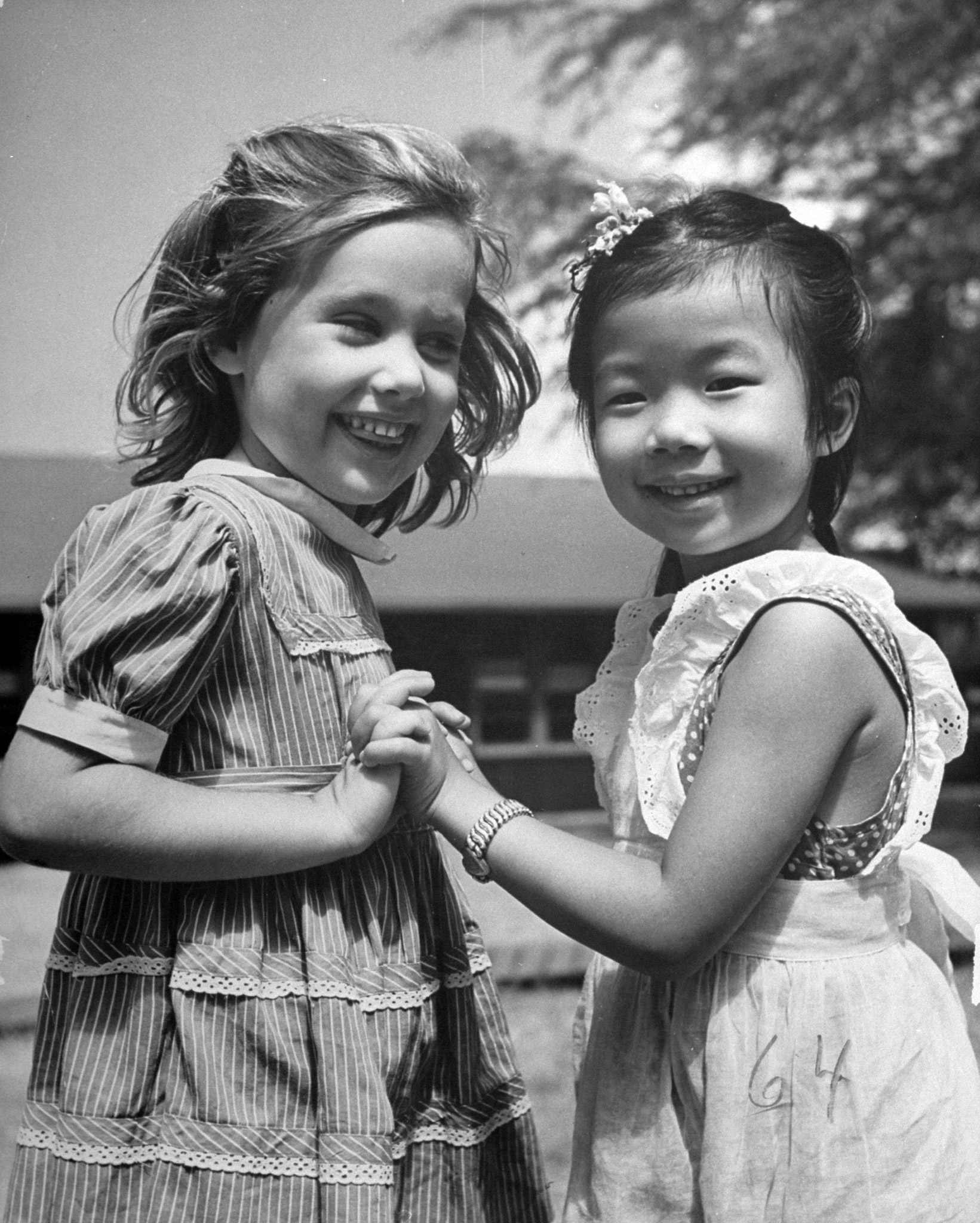 Mary Lou Parker, 4, plays with Letty Mai Pang, 5, a Chinese, in the playground of a polyracial Honolulu school.