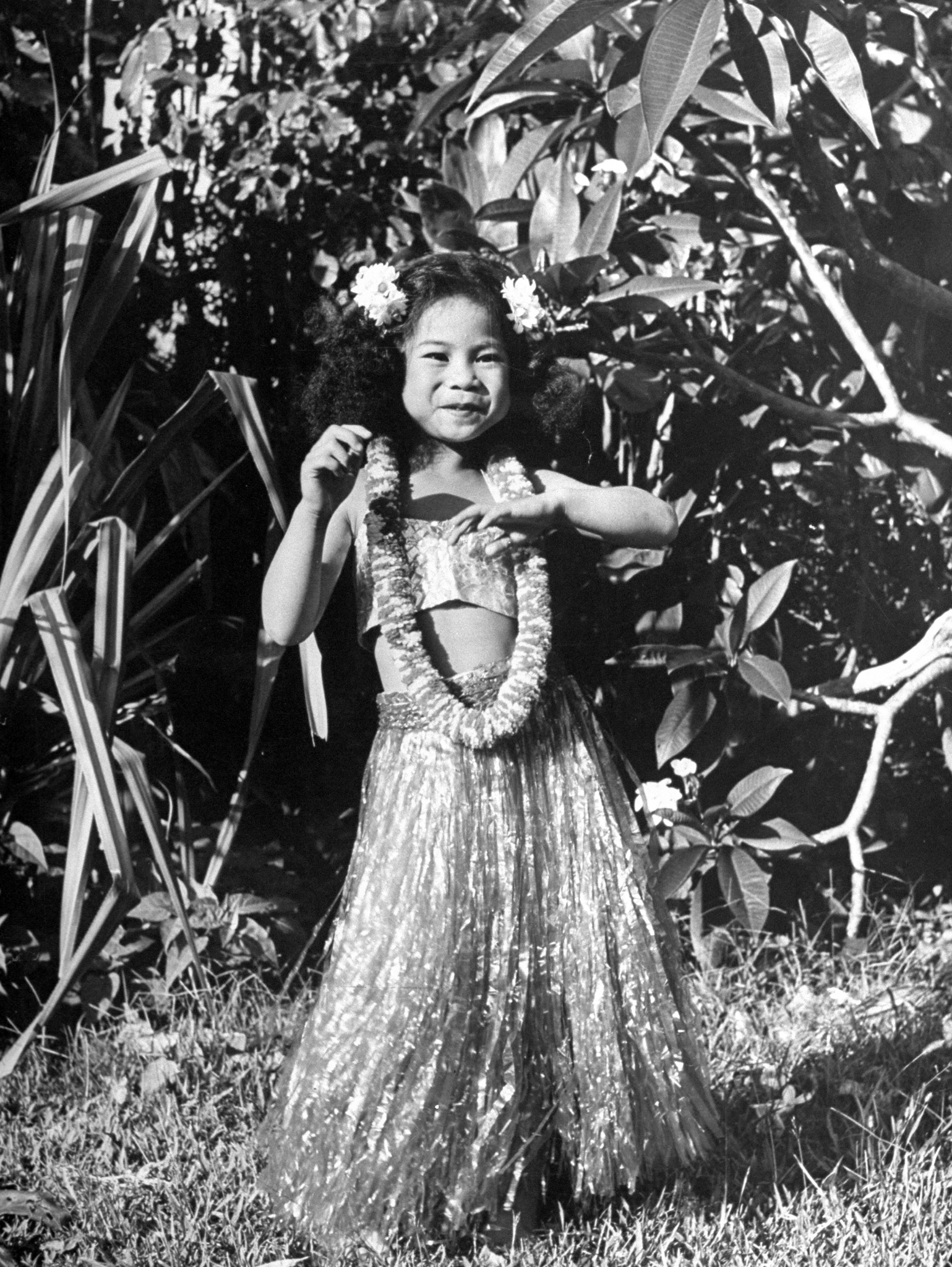 Young girl dancing in hula skirt.