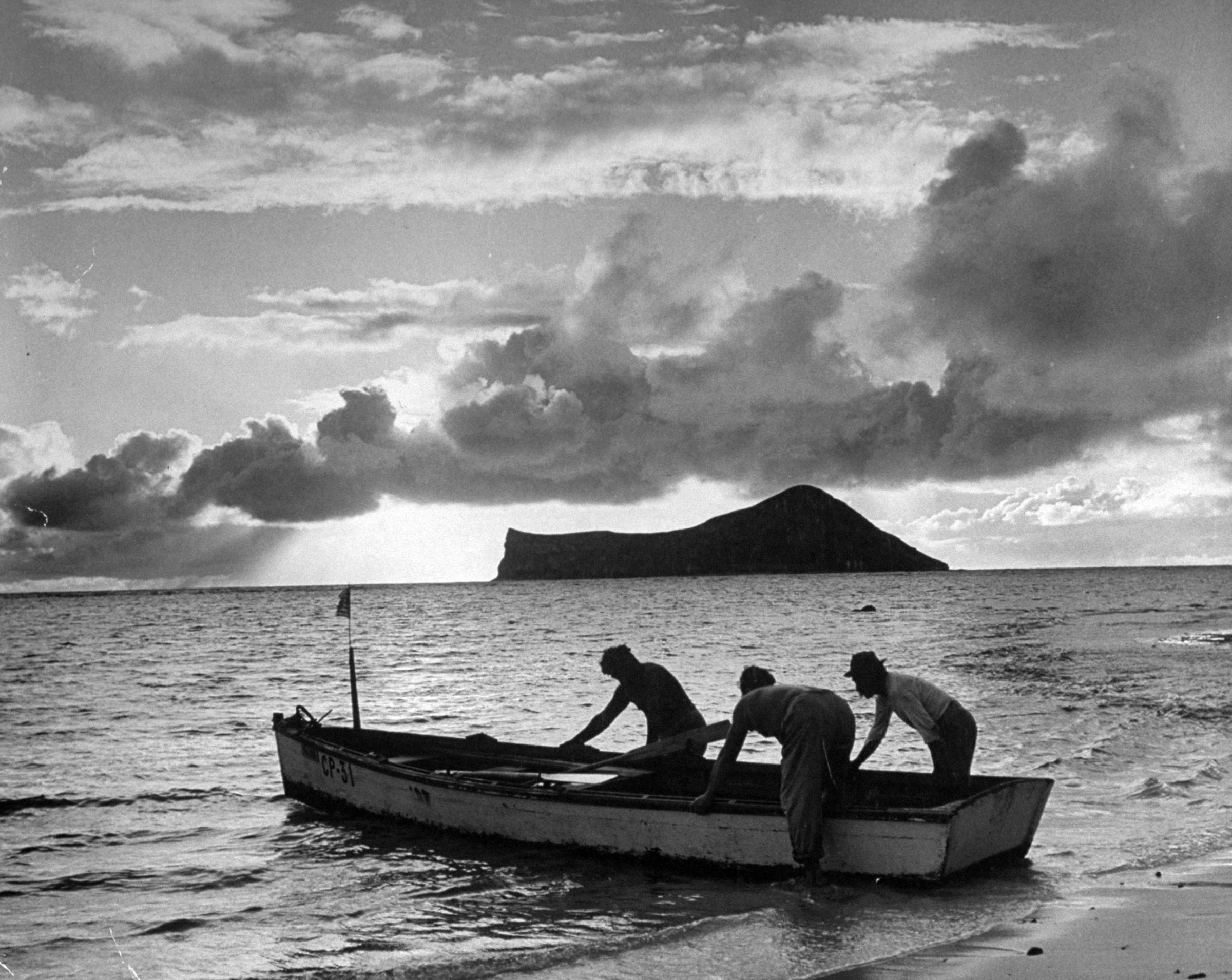 At dawn Hawaiians put out to sea to pull in their fish nets. By law, their boat flies the American flag at bow.