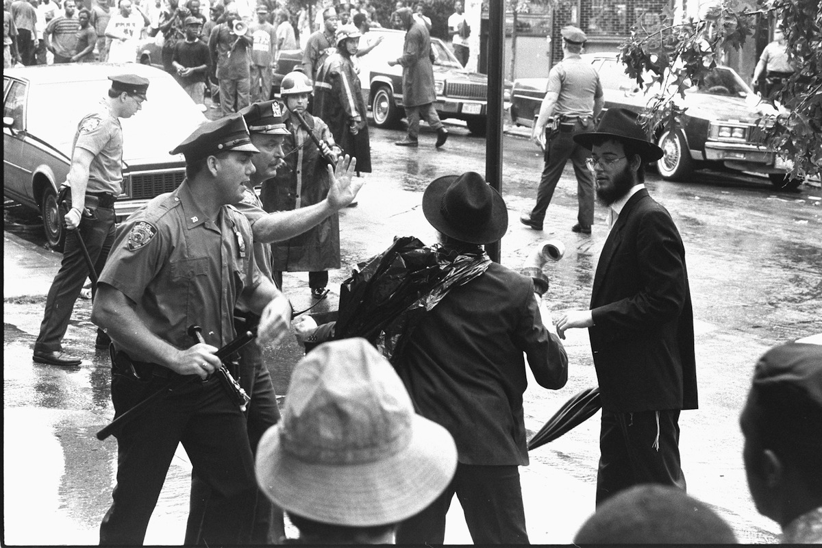Police officers try to calm Hasidim during a confrontation at Utica Ave. and President St. during Crown Heights riots in August of 1991. (New York Daily News Archive / Getty Images)