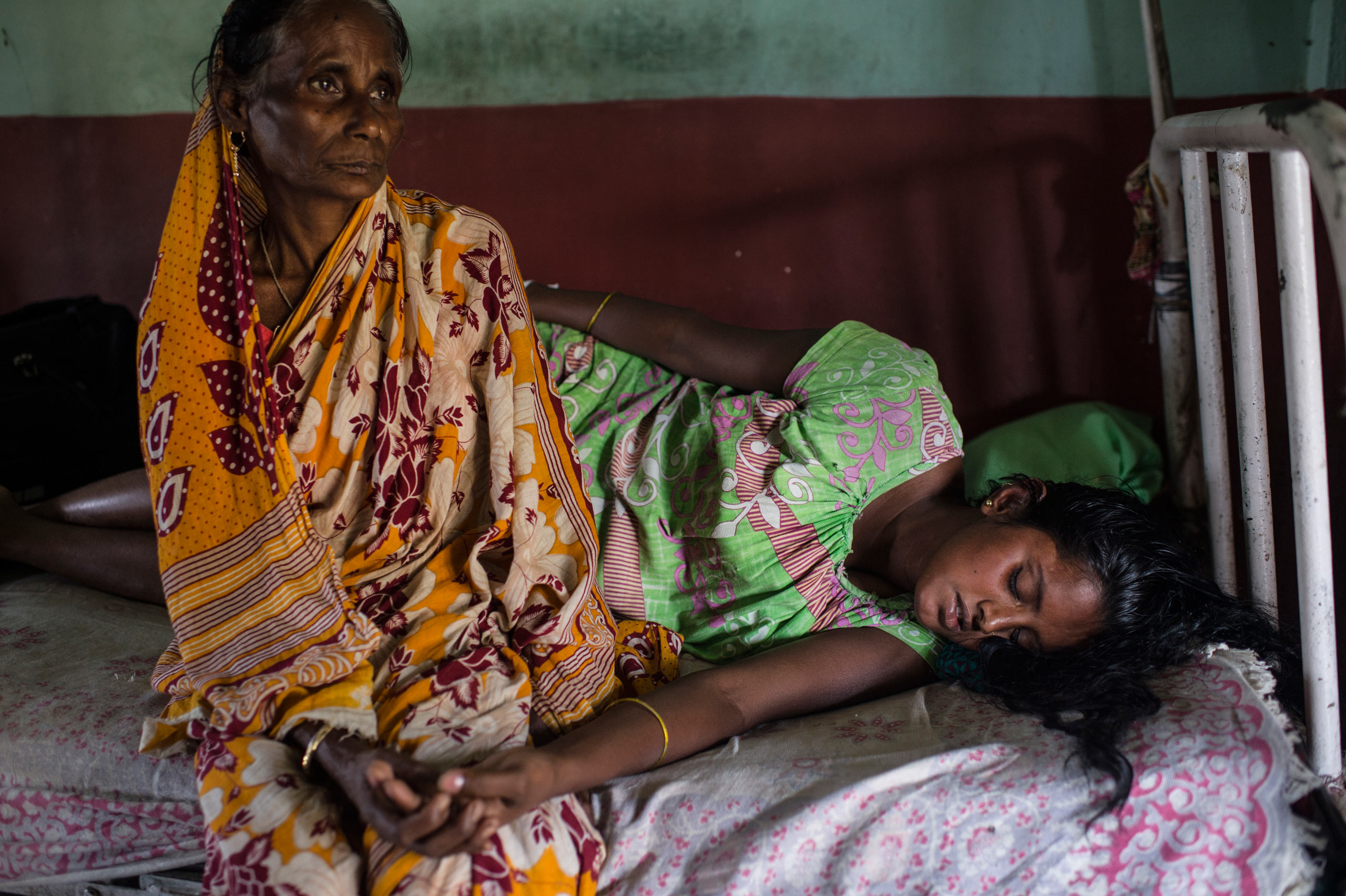 A young woman is comforted by her mother-in-law while in labor in the maternity ward at the Dhekiajuli Community Health Center in Assam, India. April 8, 2015.