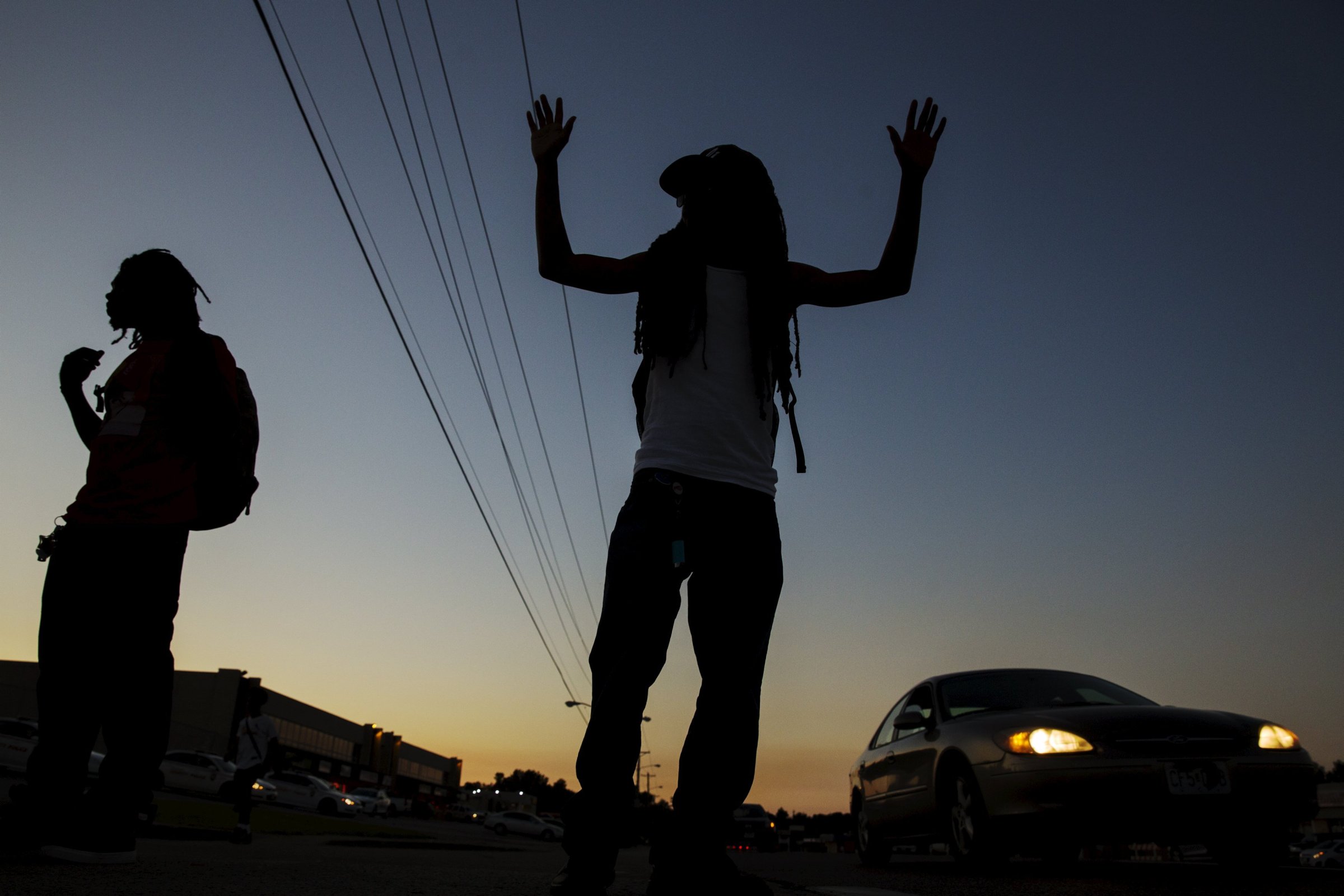 A man gestures on the side of West Florissant Ave. as a much smaller group of demonstrators prepare to protest for another night in Ferguson, Missouri