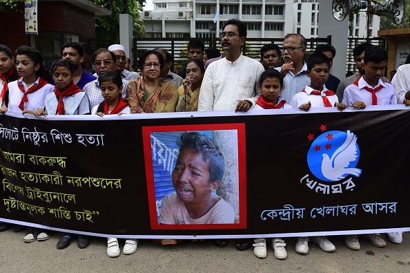 Bangladeshi protesters carry a banner during a demonstration against the lynching of a 13-year-old boy in Dhaka on July 14, 2015 (Munir Uz Zaman—AFP/Getty Images)