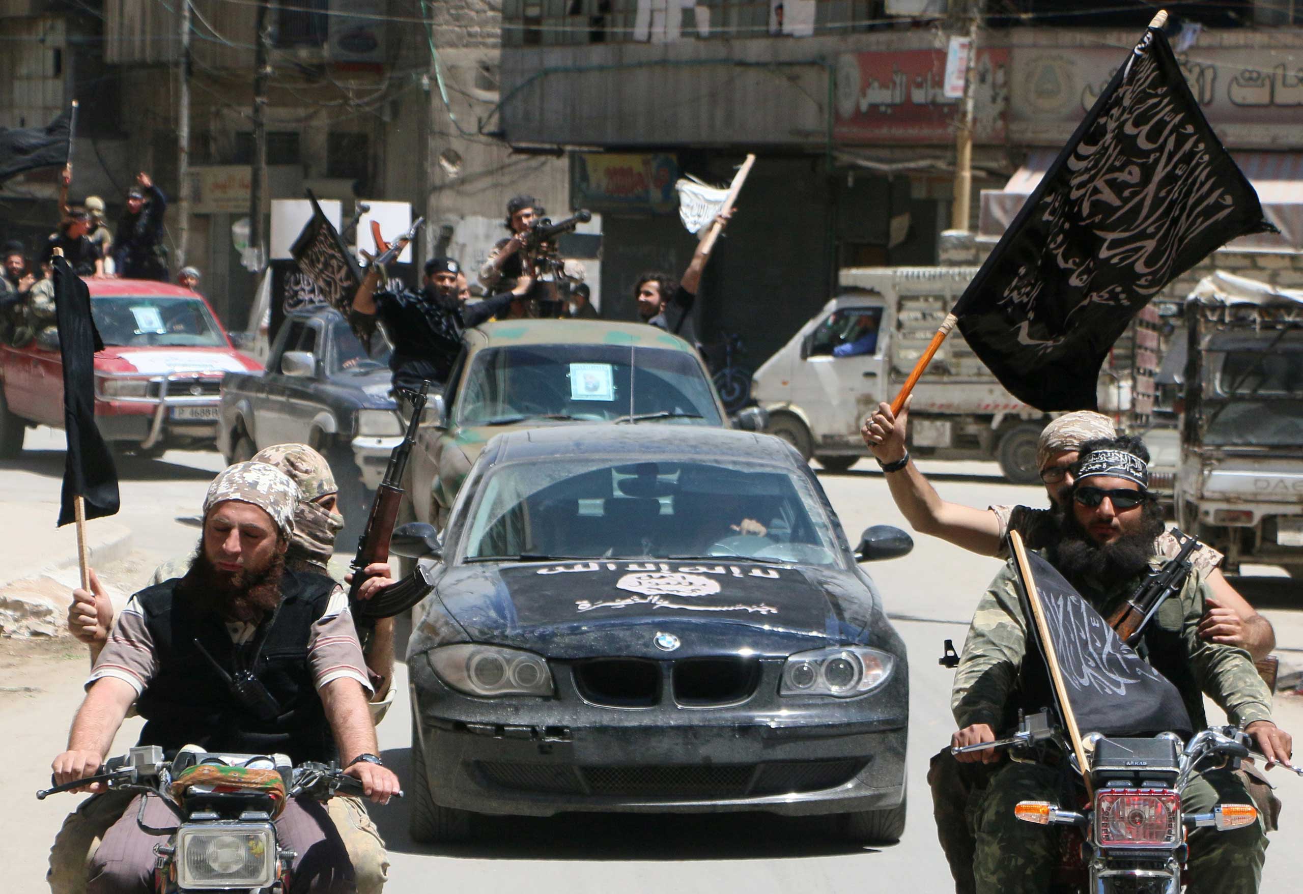 Fighters from Al-Qaeda's Syrian affiliate Al-Nusra Front drive in the northern Syrian city of Aleppo flying Islamist flags as they head to a frontline, on May 26, 2015. (Fadi Al-Halabi—AFP/Getty Images)