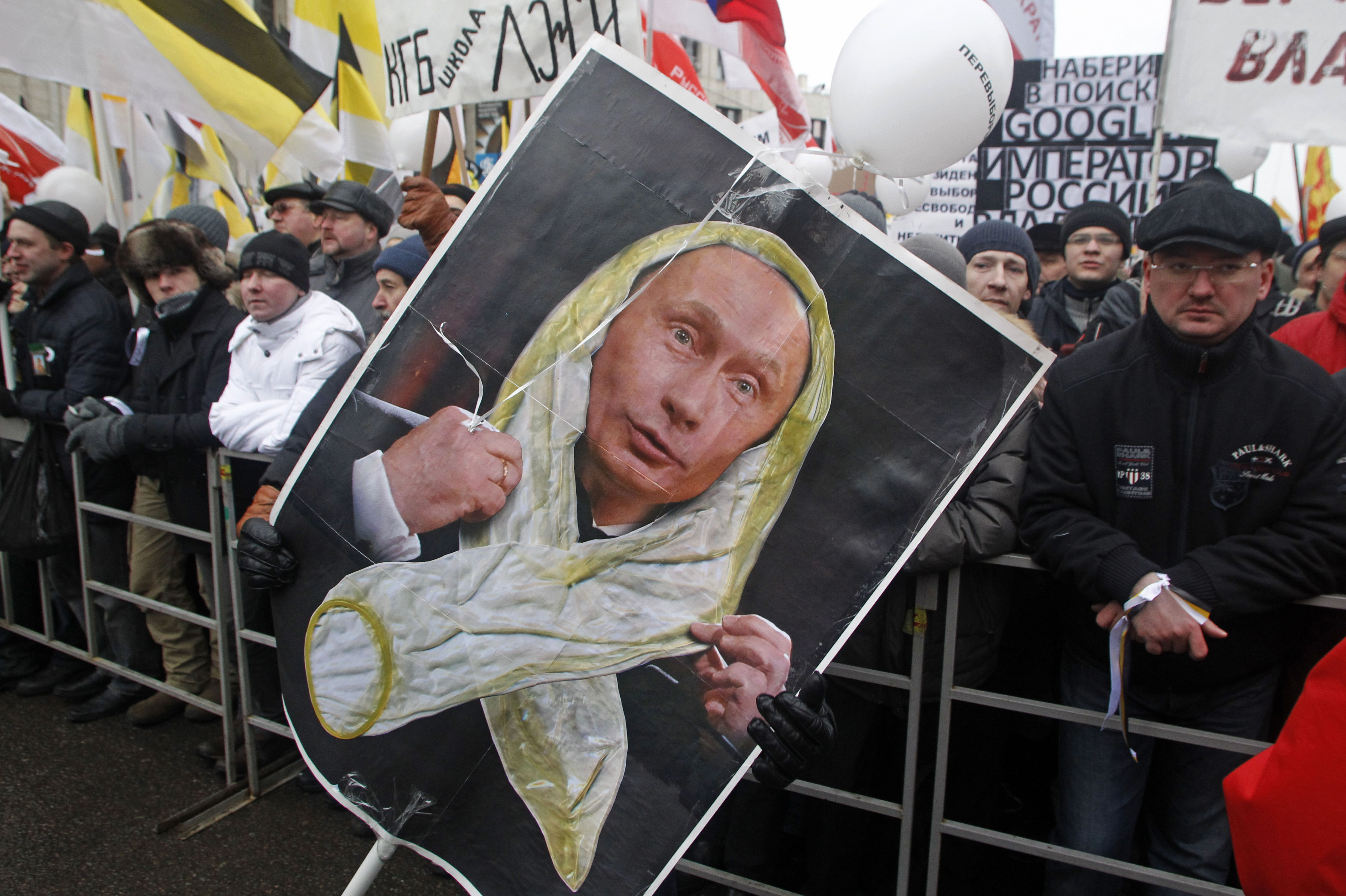 This is  a  Saturday, Dec. 24, 2011 file photo of  protesters holding a portrait of Russian Prime Minister Vladimir Putin changed by an unidentified satirical artist to show him wearing a condom, during a protest against alleged vote rigging in Russia's parliamentary elections in Moscow, Russia (Mikhail Metzel—AP)