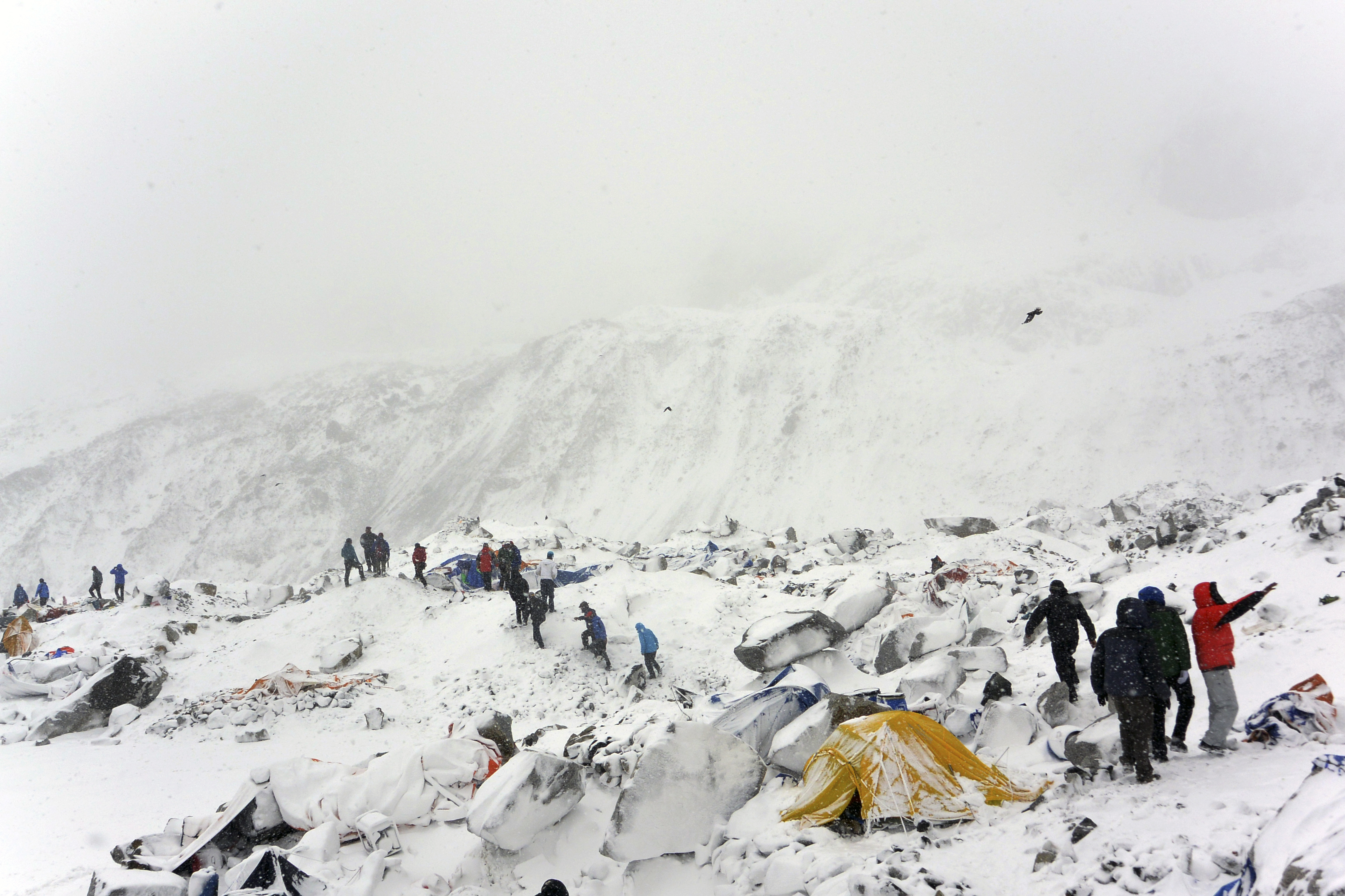 In this April 25, 2015 photo, climbers search through crushed tents for fellow climbers caught in an avalanche at a base camp on the Nepal side of Mount Everest. (Mariusz Malkowski—AP)
