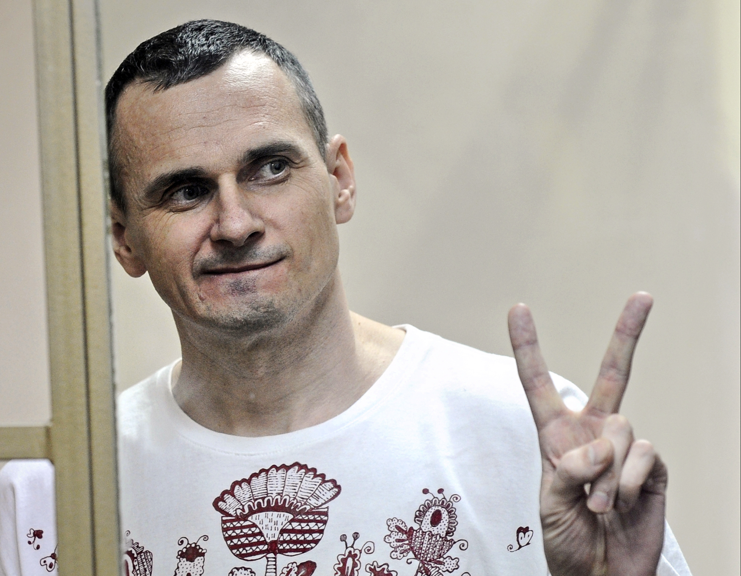 Oleg Sentsov gestures as the verdict is delivered, as he stands behind bars at a court in Rostov-on-Don, Russia, on Aug. 25, 2015 (STR—AP)