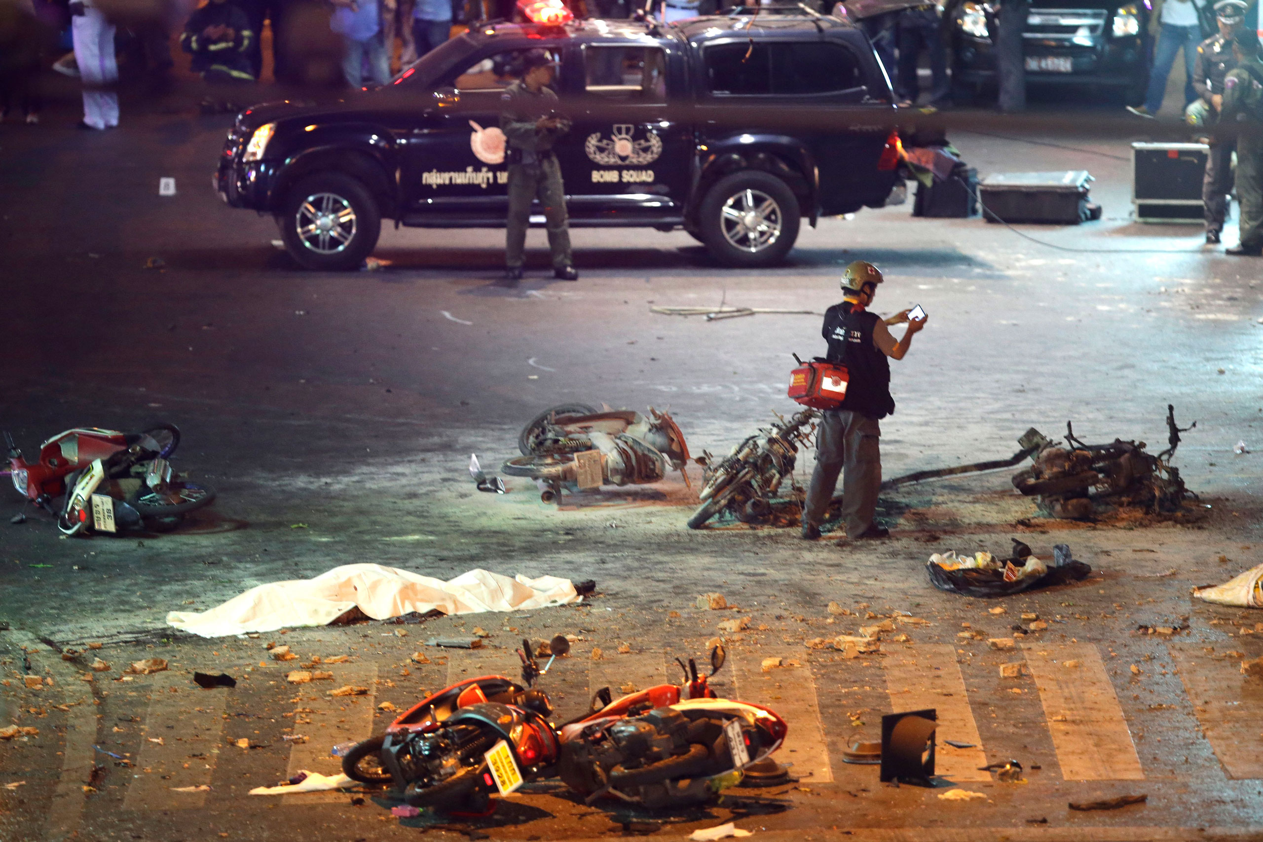 A policeman photographs debris from an explosion in central Bangkok, Thailand, on Aug. 17, 2015. (Mark Baker—AP)