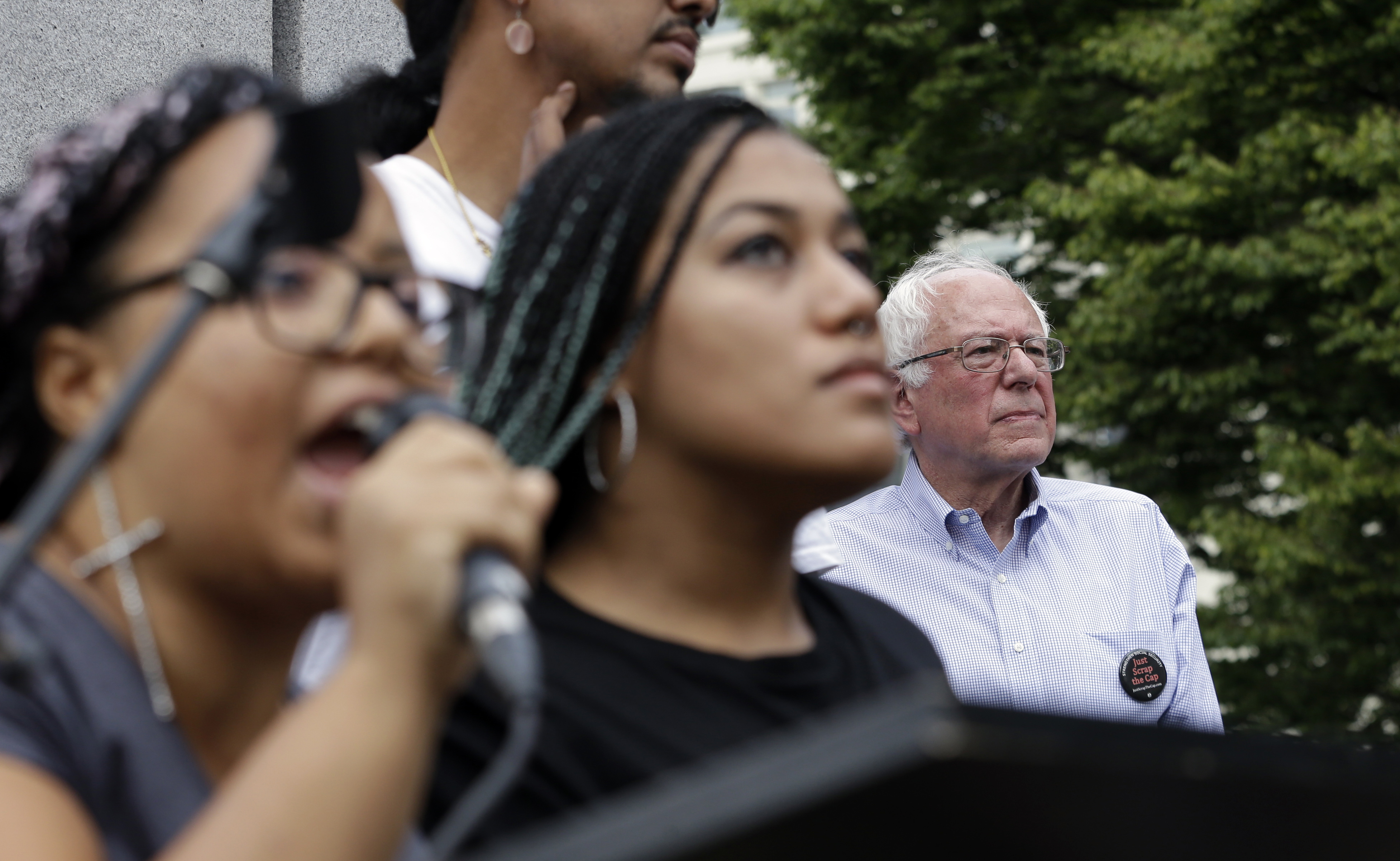 Marissa Johnson, left, speaks as Mara Jacqueline Willaford stands with her and Democratic presidential candidate Sen. Bernie Sanders, I-Vt., stands nearby as the two women take over the microphone at a rally on Aug. 8, 2015, in downtown Seattle. (Elaine Thompson—AP)