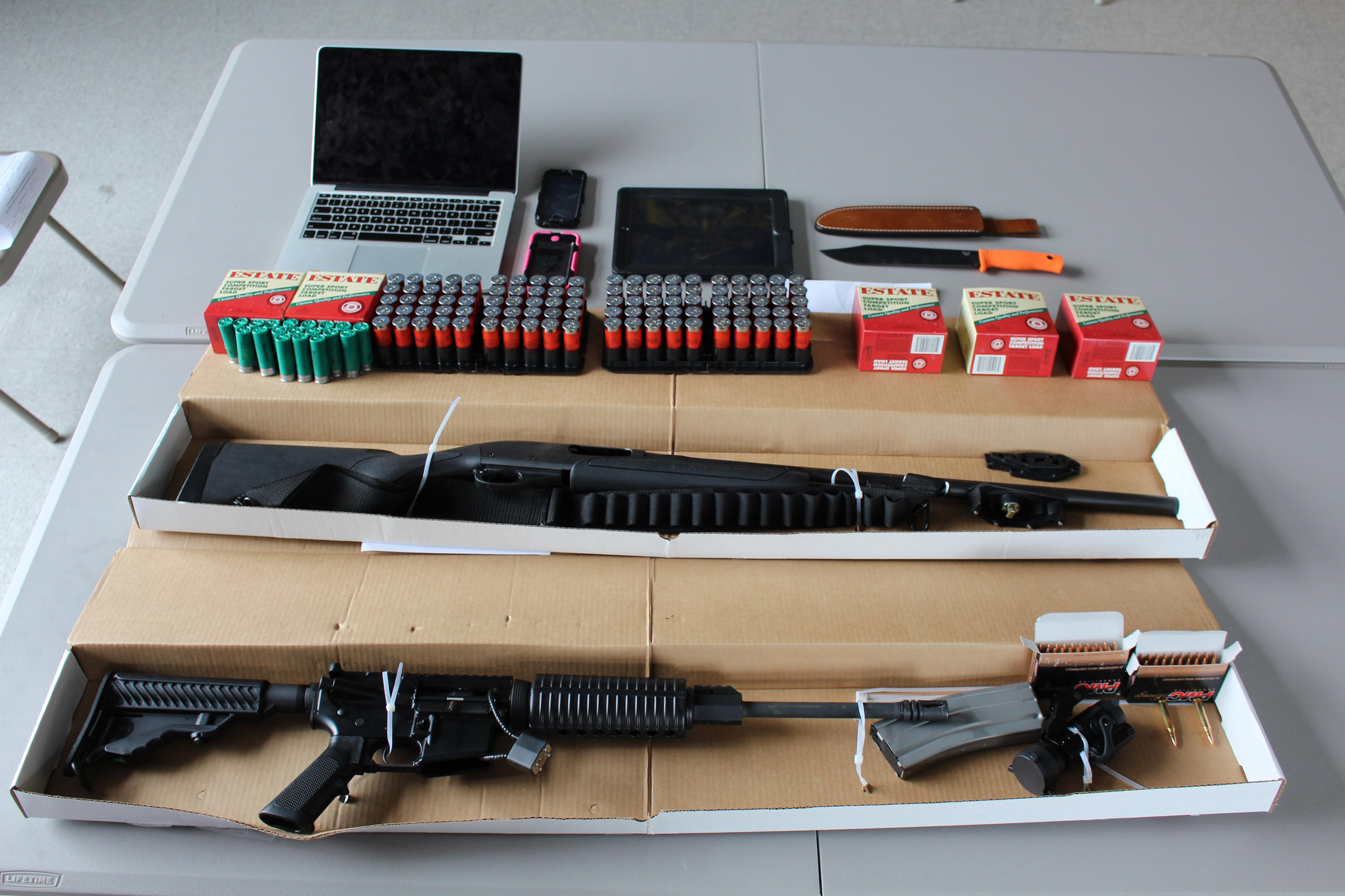This photo, provided by the Boston Police Department, shows a 12-gauge Remington shotgun, a DPM5 Model AR-15 rifle, several hundred rounds of ammunition, and a hunting knife, confiscated by the police in Boston on Aug. 21, 2015. (Boston Police Department)