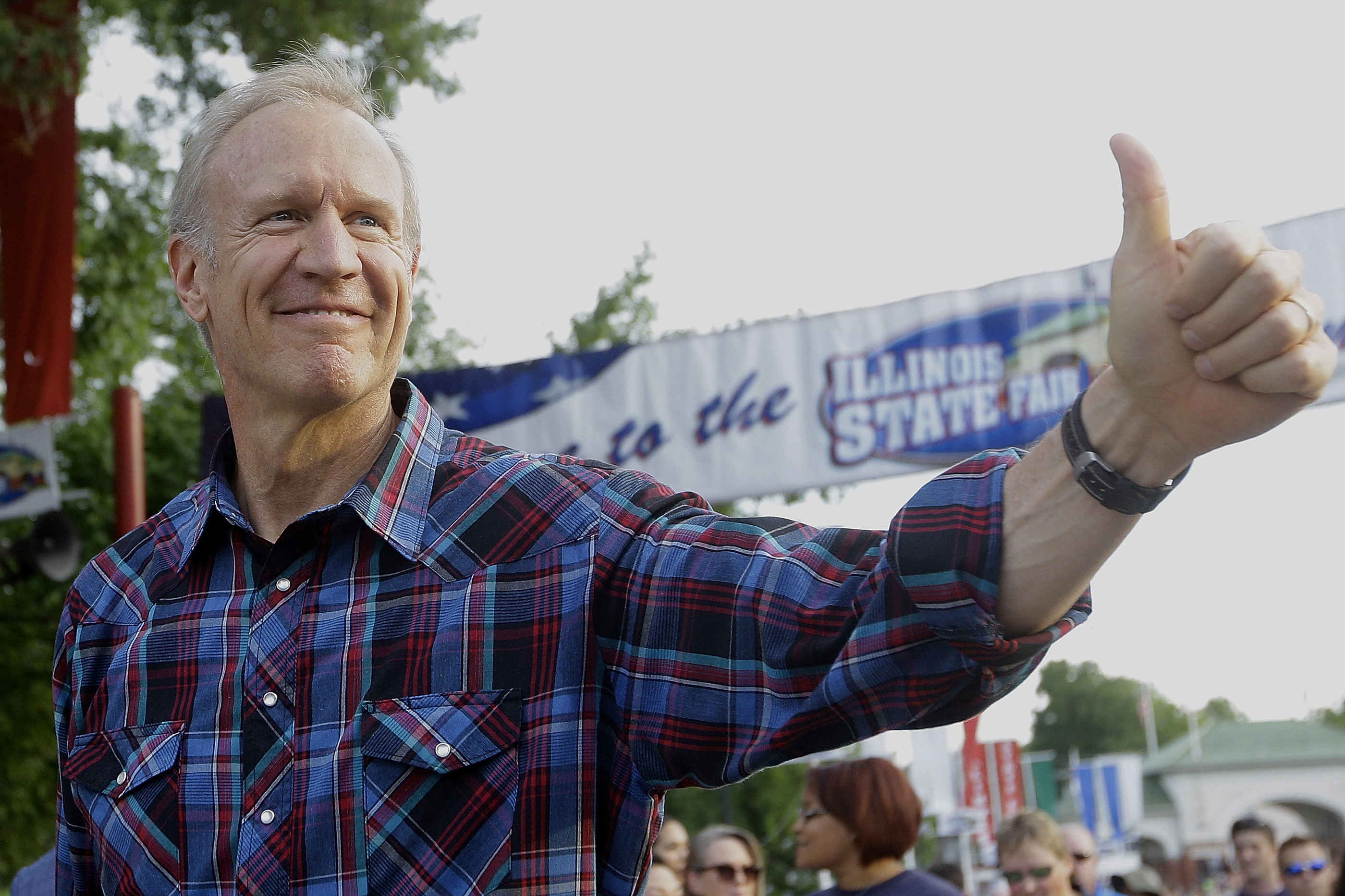 Illinois Gov. Bruce Rauner greets fairgoers during the Twilight Parade at the Illinois State Fair on Aug. 13, 2015, in Springfield, Ill. (Seth Perlman—AP)