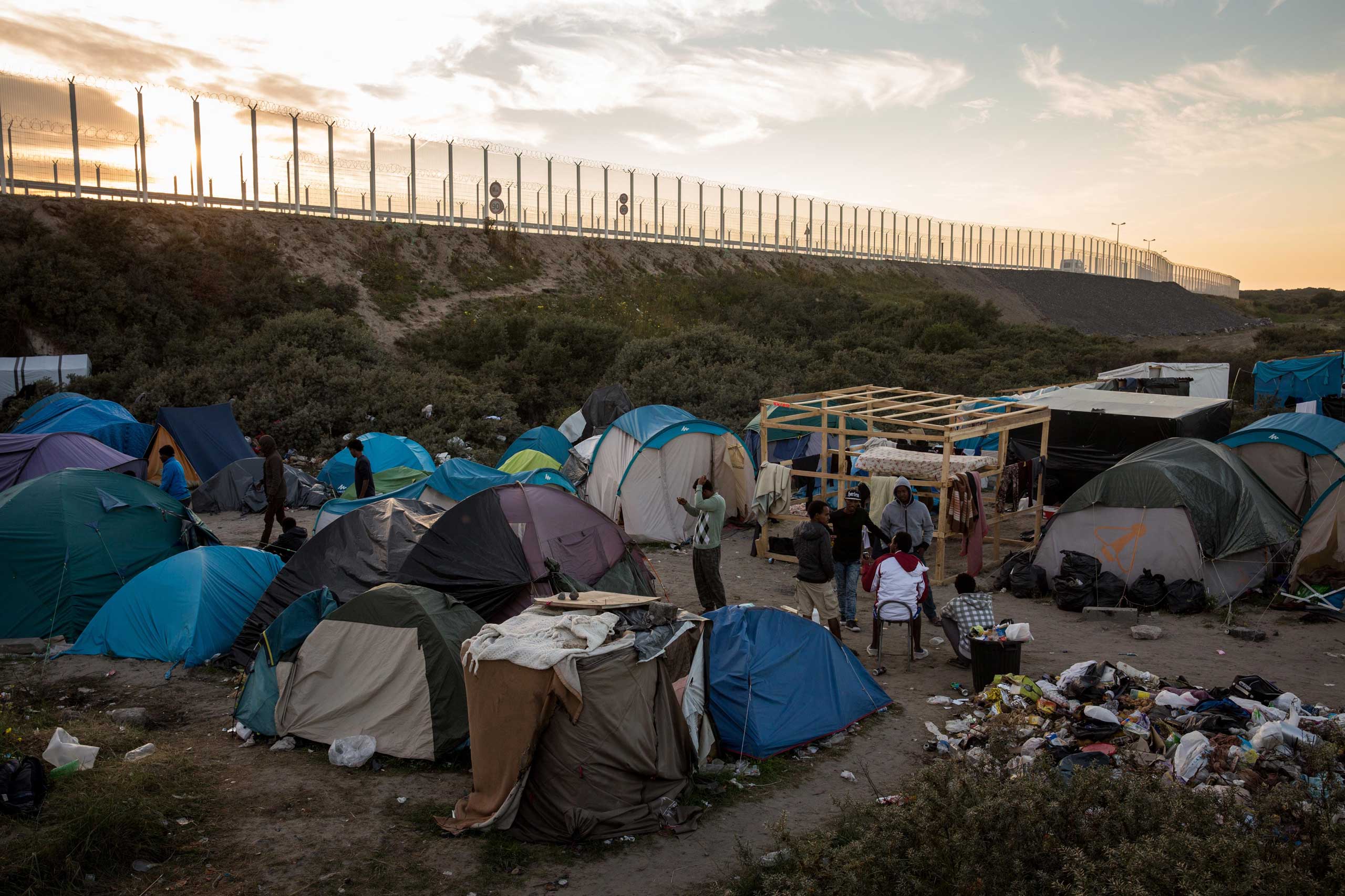 The sun sets behind a make shift camp near the port of Calais, on Aug. 2, 2015. (Rob Stothard—Getty Images)