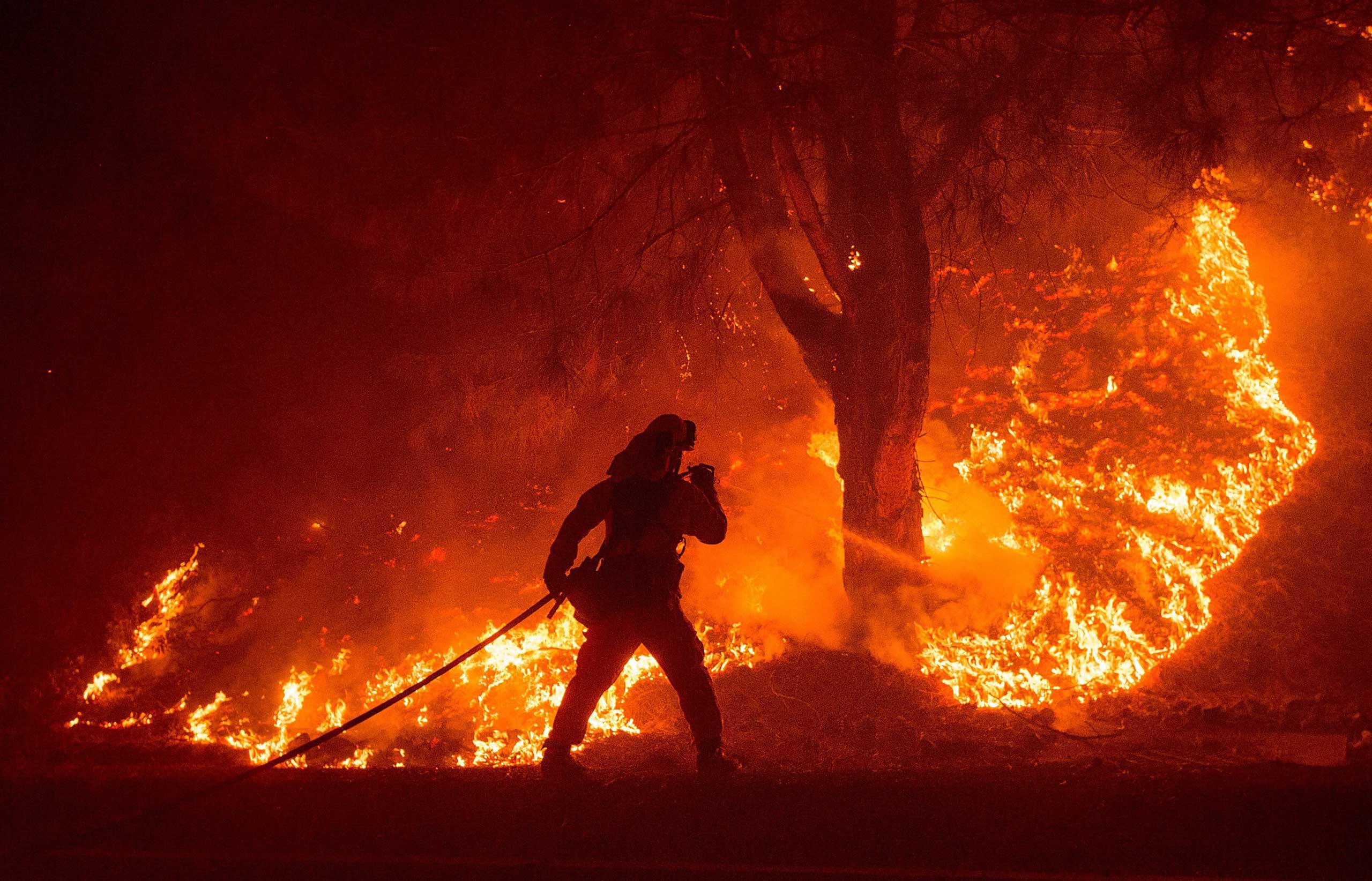 A firefighter sprays water while battling the Rocky fire near Clearlake, Calif. on Aug. 2, 2015.