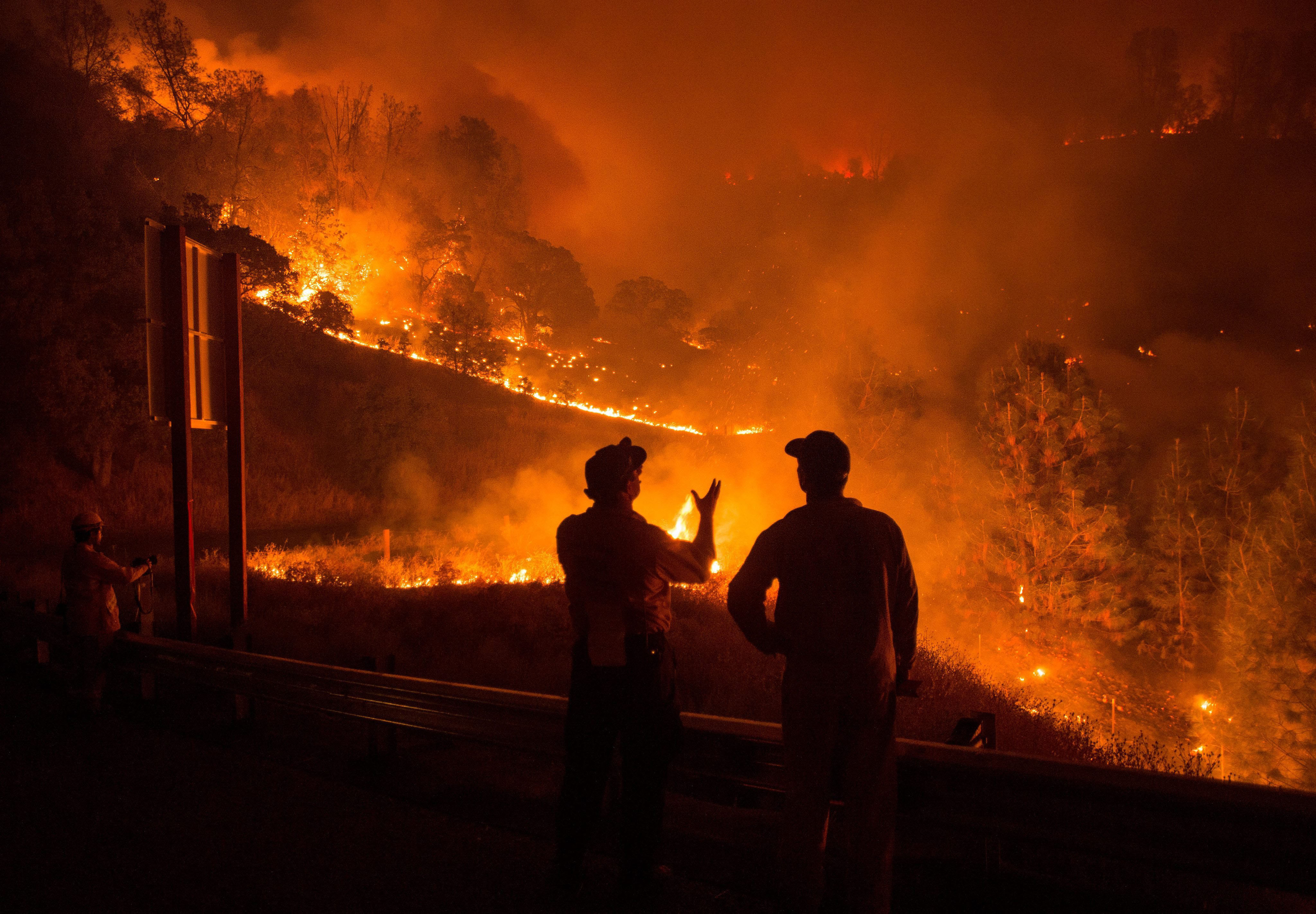 Firefighters Richard Dykhouse, left, and Dan McCabe confer as the Rocky fire burns near Clearlake, Calif. on Aug. 2, 2015. (Noah Berger—EPA)