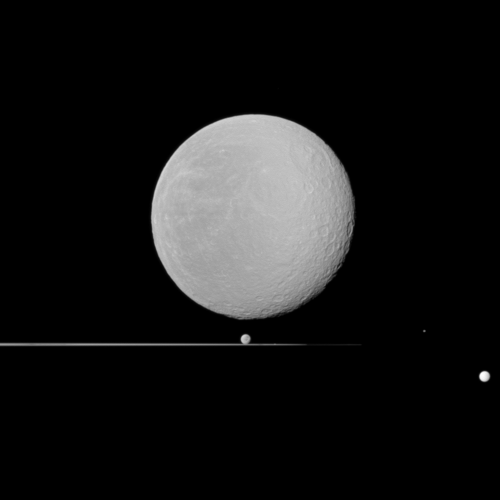 Five moons -- dominated by Rhea in the foreground -- share this Cassini spacecraft view with Saturn's rings seen nearly edge-on. Rhea (1,528 kilometers, or 949 miles across) is largest here and is closest to Cassini. Dione (1,123 kilometers, or 698 miles across) can be seen just above the rings near the center of the image. Tiny Prometheus (86 kilometers, or 53 miles across) is just barely visible in the rings to the right of Dione. Epimetheus (113 kilometers, or 70 miles across) is to the right of the rings, and Tethys (1,062 kilometers, or 660 miles across) is on the extreme right of the image. This view looks toward the anti-Saturn side of Rhea and toward the northern, sunlit side of the rings from just above the ringplane. The image was taken in visible light with the Cassini spacecraft wide-angle camera on Jan. 11, 2011. The view was obtained at a distance of approximately 61,000 kilometers (38,000 miles) from Rhea and at a Sun-Rhea-spacecraft, or phase, angle of 15 degrees. Scale on Rhea is 4 kilometers (2 miles) per pixel. The Cassini-Huygens mission is a cooperative project of NASA, the European Space Agency and the Italian Space Agency. The Jet Propulsion Laboratory, a division of the California Institute of Technology in Pasadena, manages the mission for NASA's Science Mission Directorate, Washington, D.C. The Cassini orbiter and its two onboard cameras were designed, developed and assembled at JPL. The imaging operations center is based at the Space Science Institute in Boulder, Colo. For more information about the Cassini-Huygens mission visit http://saturn.jpl.nasa.gov/. The Cassini imaging team homepage is at http://ciclops.org.