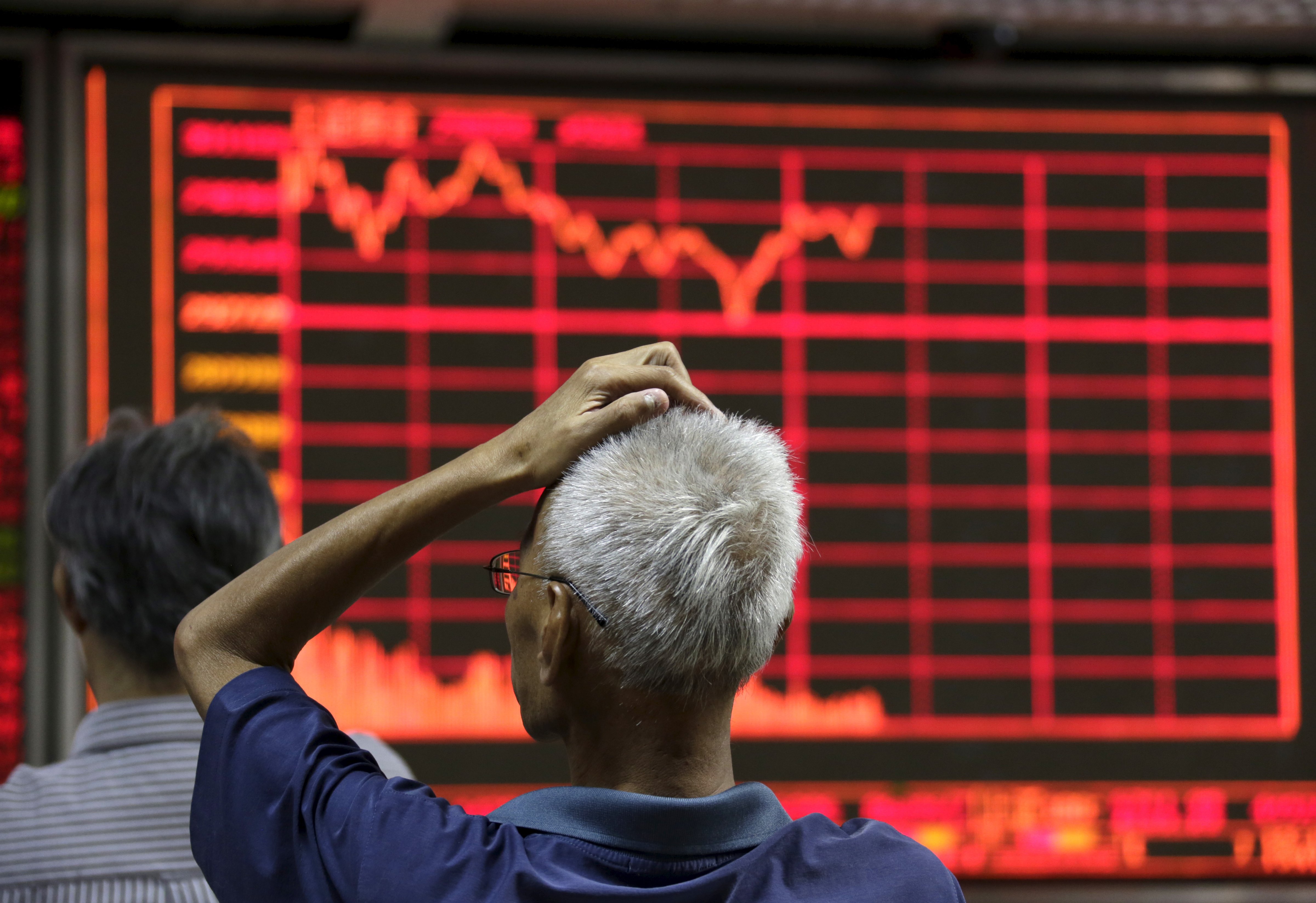An investor looks at an electronic board showing stock information at a brokerage house in Beijing on Aug. 27, 2015. (Jason Lee—Reuters)