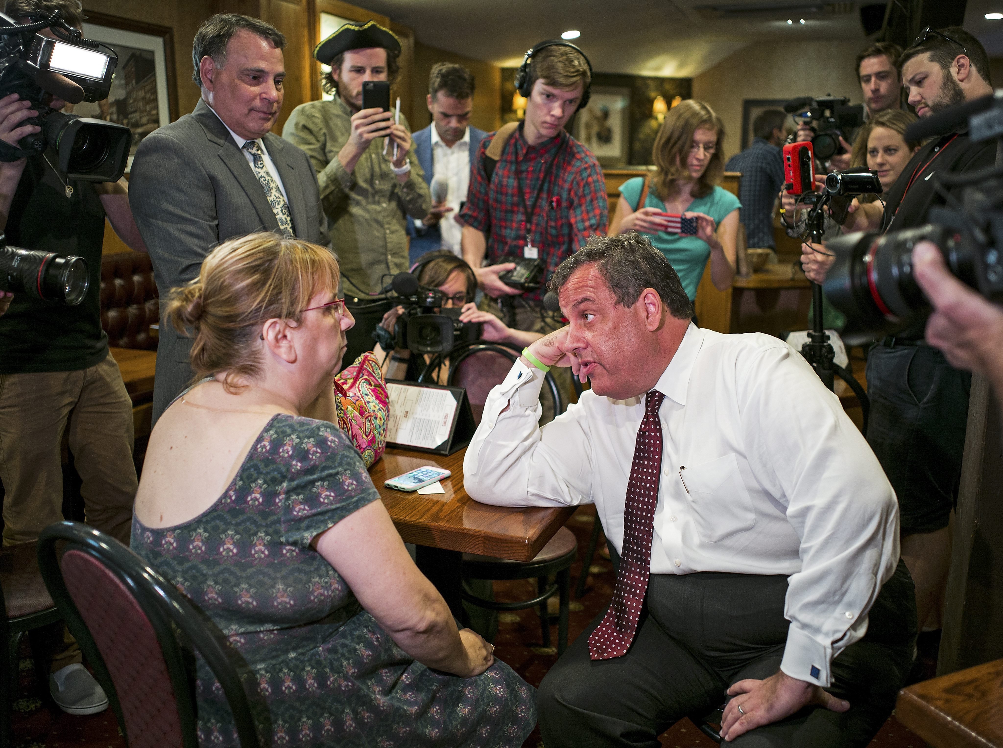 Chris Christie, Governor of New Jersey and candidate in the Republicans' presidential candidates race, talks with a voter at The Puritan Backroom in Manchester, N.H. on Aug. 3, 2015.