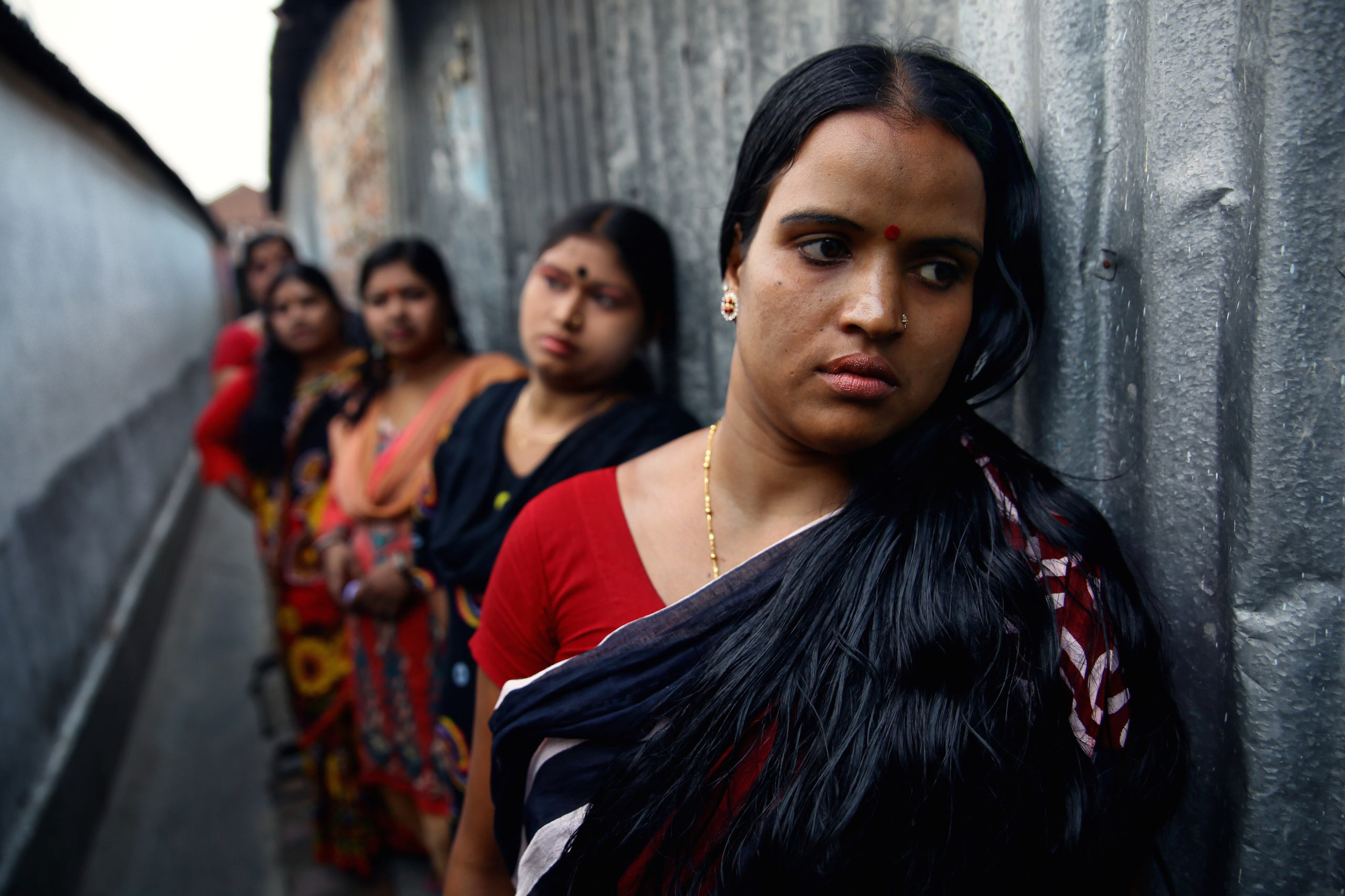 Jyotsna, 29, leads a line of sex workers, awaiting customers in an alleyway of Sonagachi, India.