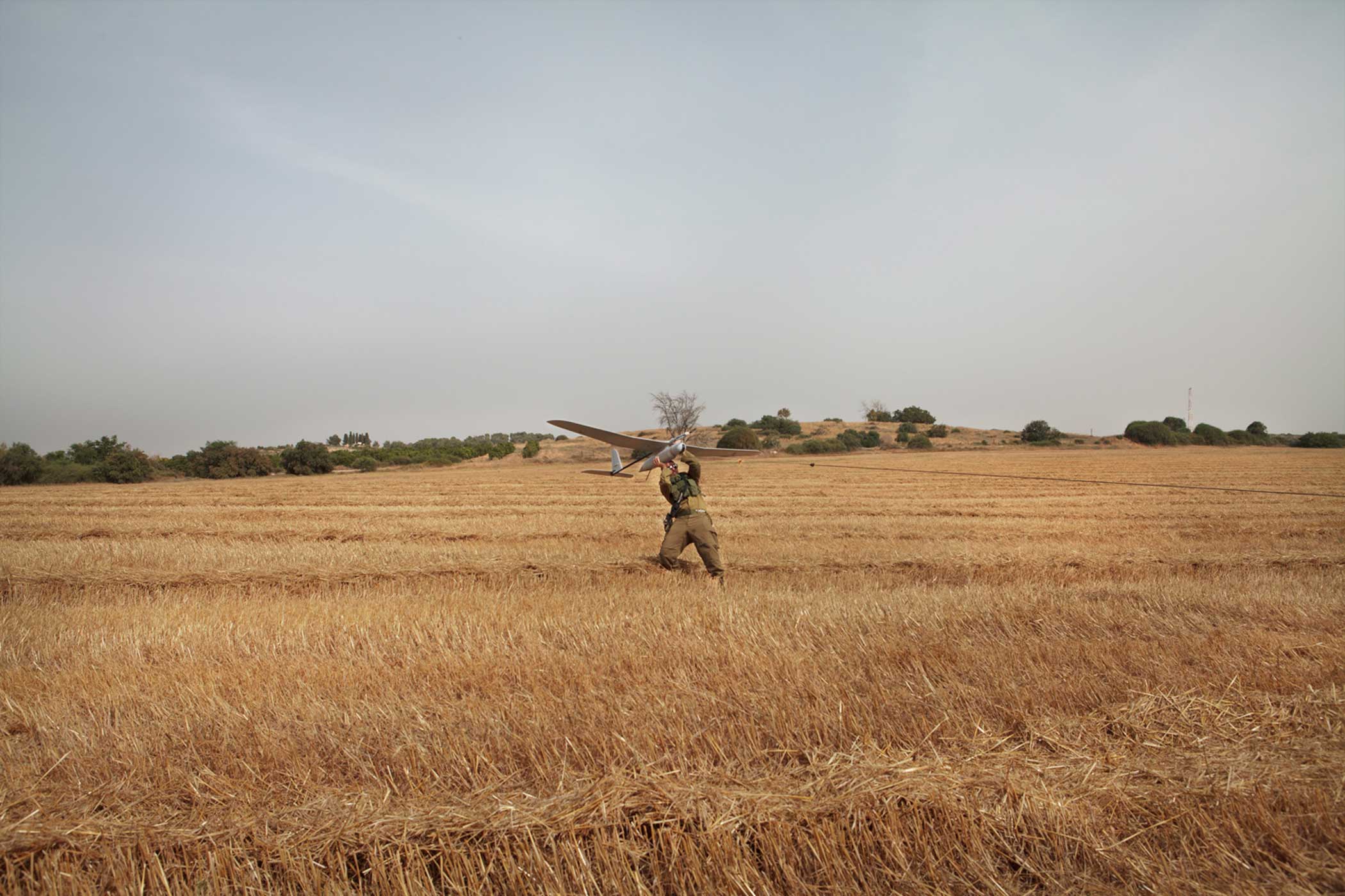 An Israeli soldier from the Sky Rider Unit launches a Skylark mini-Unmanned Arial Vehicle (UAV) during a demonstration close to the border with Gaza.   Sky Rider units are part of the artillery brigade and operate on the ground either independently or with other infantry soldiers to provide real-time video from the battlefield. The Israeli military began using the Skylark system in 2008 but it was not deployed extensively until Operation Protective Edge in the summer of 2014.   The Sky Rider unit lives with the infantry soldiers they serve with and support during their missions, unlike pilots in the Israeli Air Force (IAF) who fly larger drones and are stationed on bases far away from where the drones fly.  The drone is built by the Israeli company Elbit Systems. It weighs around 7 kilograms and can stay in the air for up to 3 hours. It’s used for intelligence, surveillance and reconnaissance (ISR) missions.