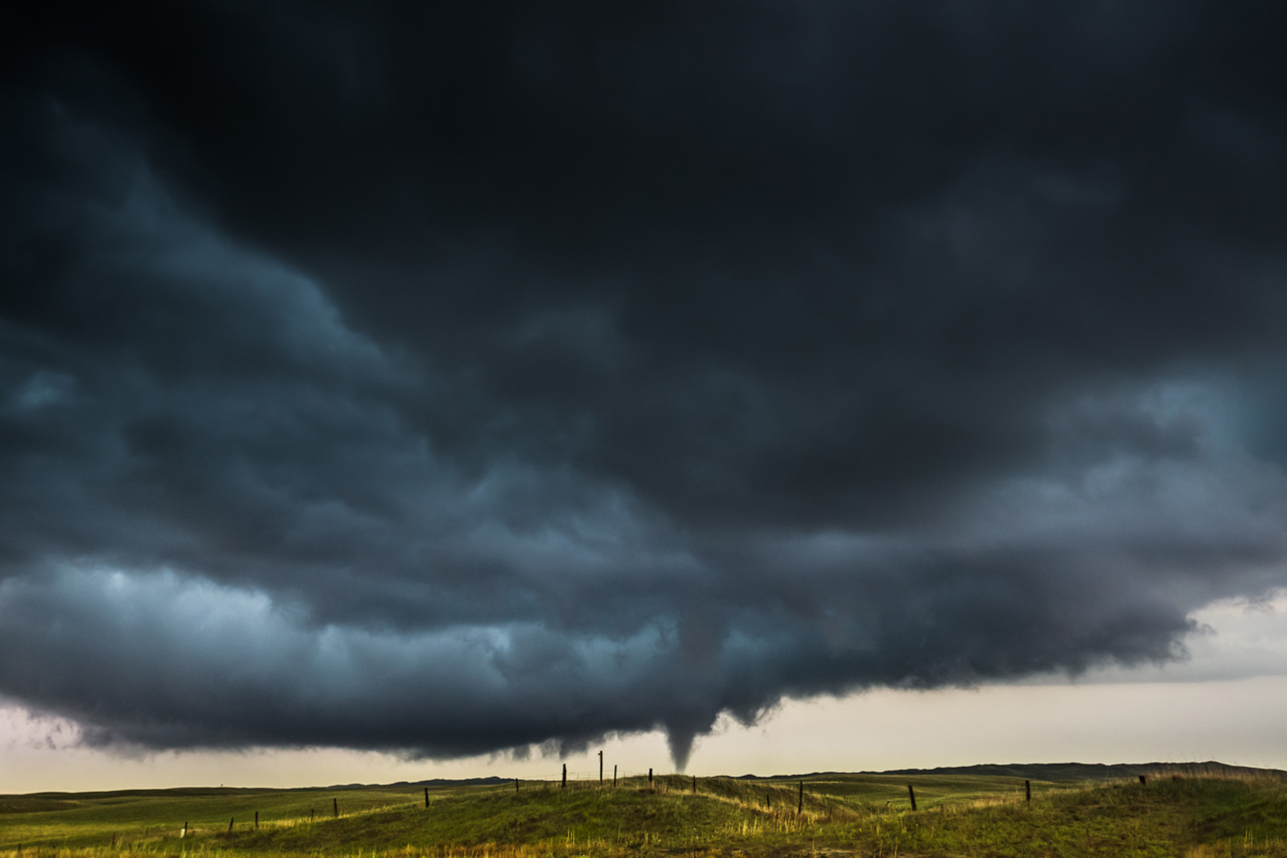 A tornado drops down at twilight on a lonely stretch of Nebraska’s Sandhills in Cherry County.